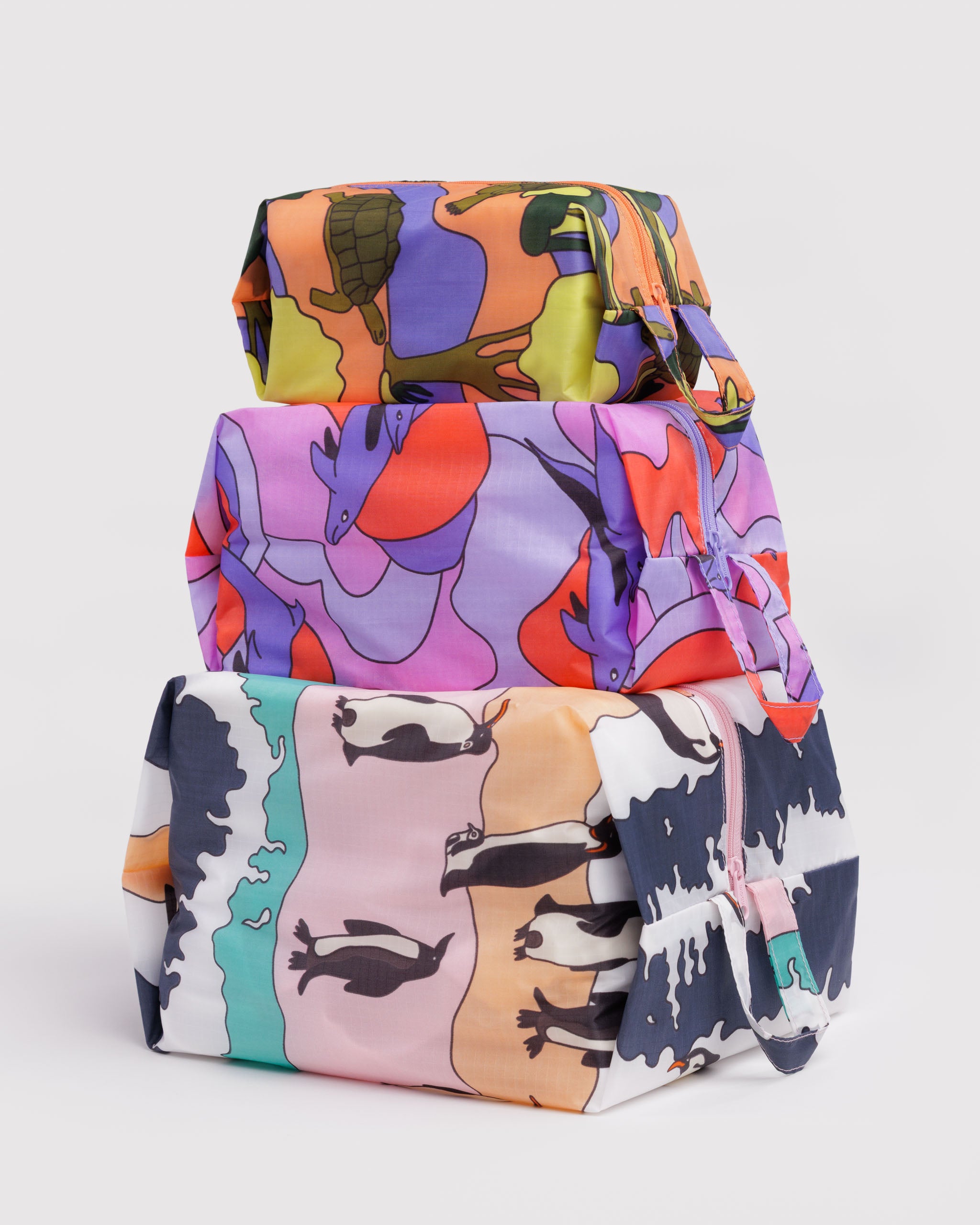 Three different sized colourful animal patterned bags filled and stacked.