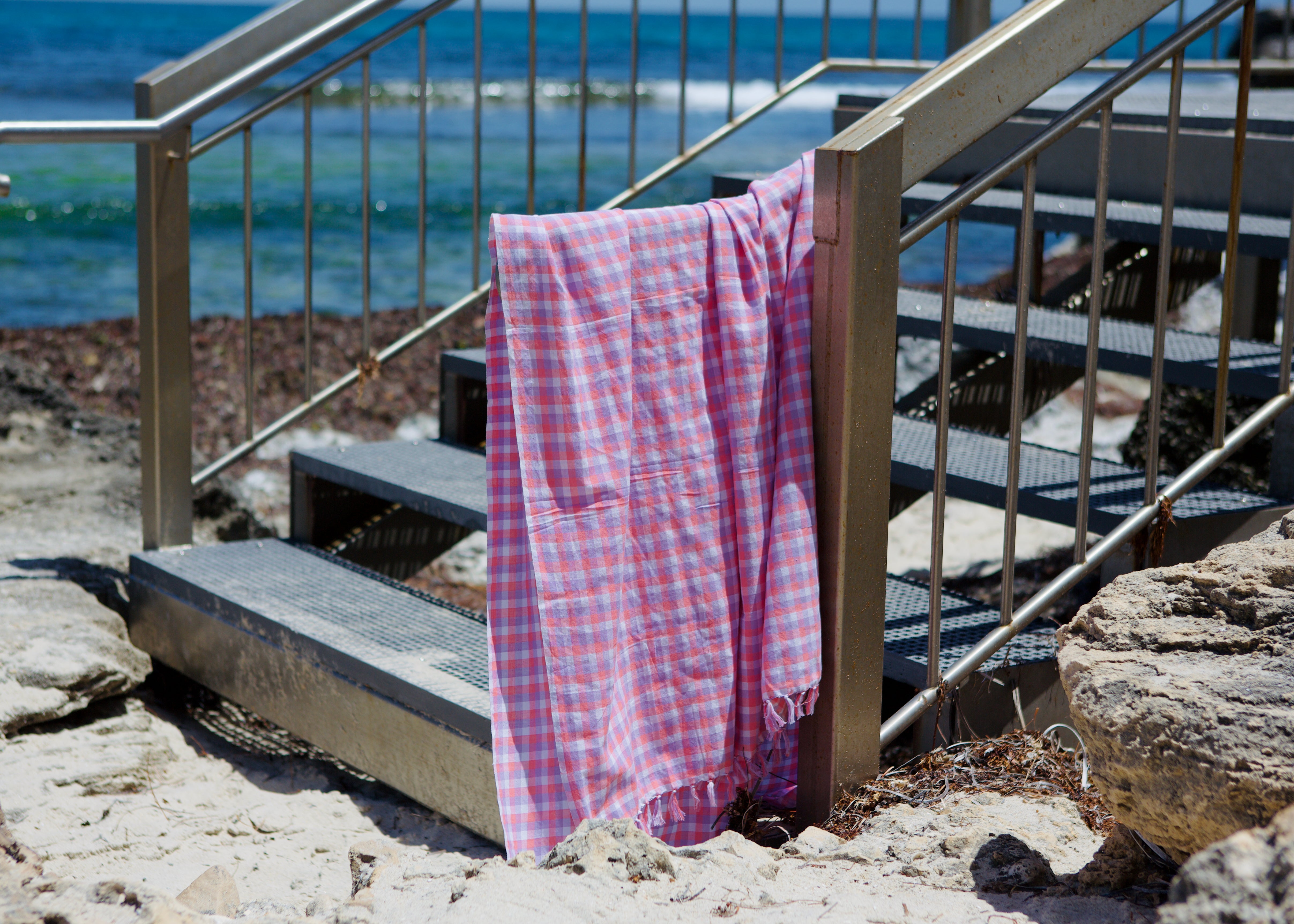 peony-check-cotton-beach-towel-over-rail-at-beach