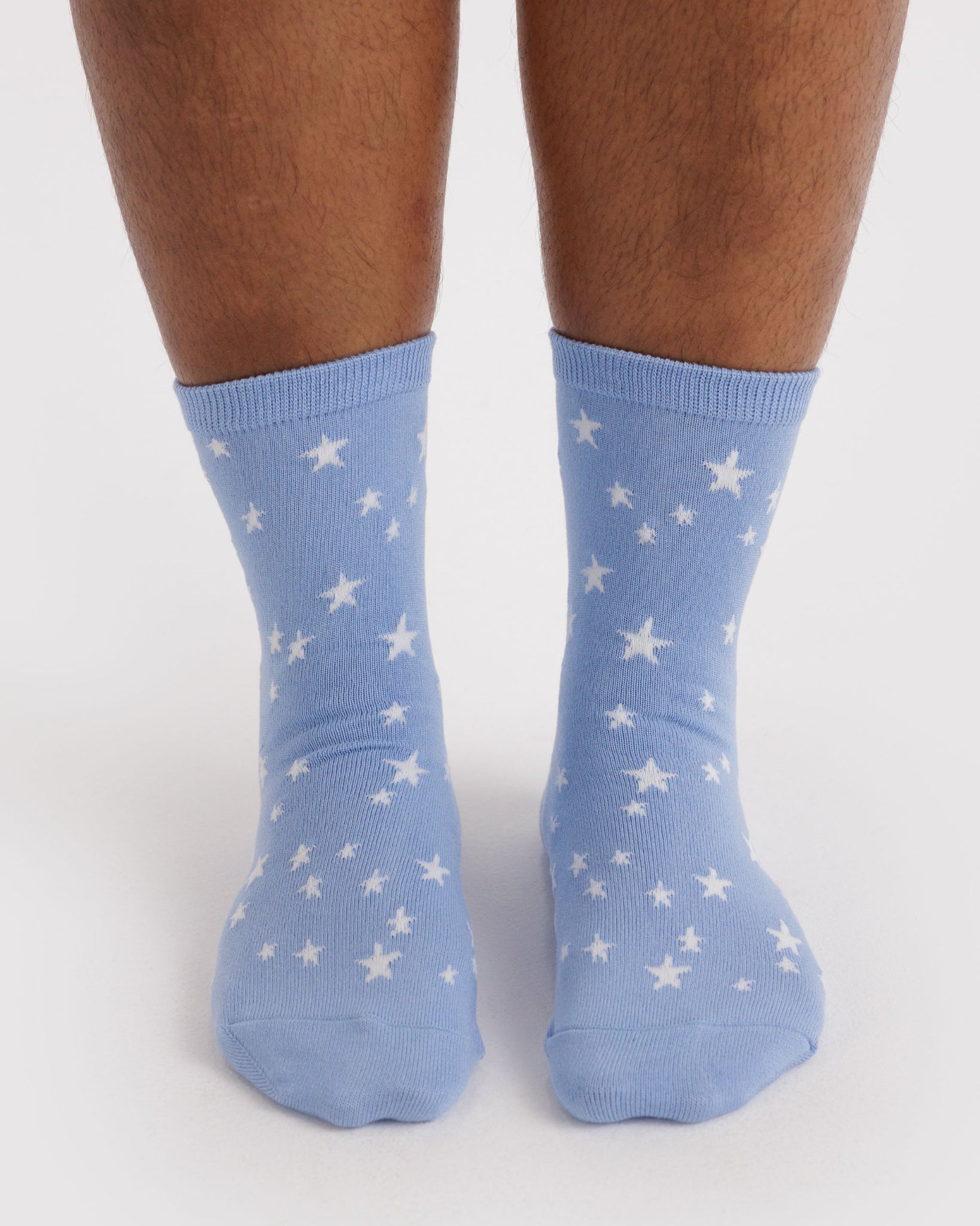 Blue socks with white star patterns worn by a person.