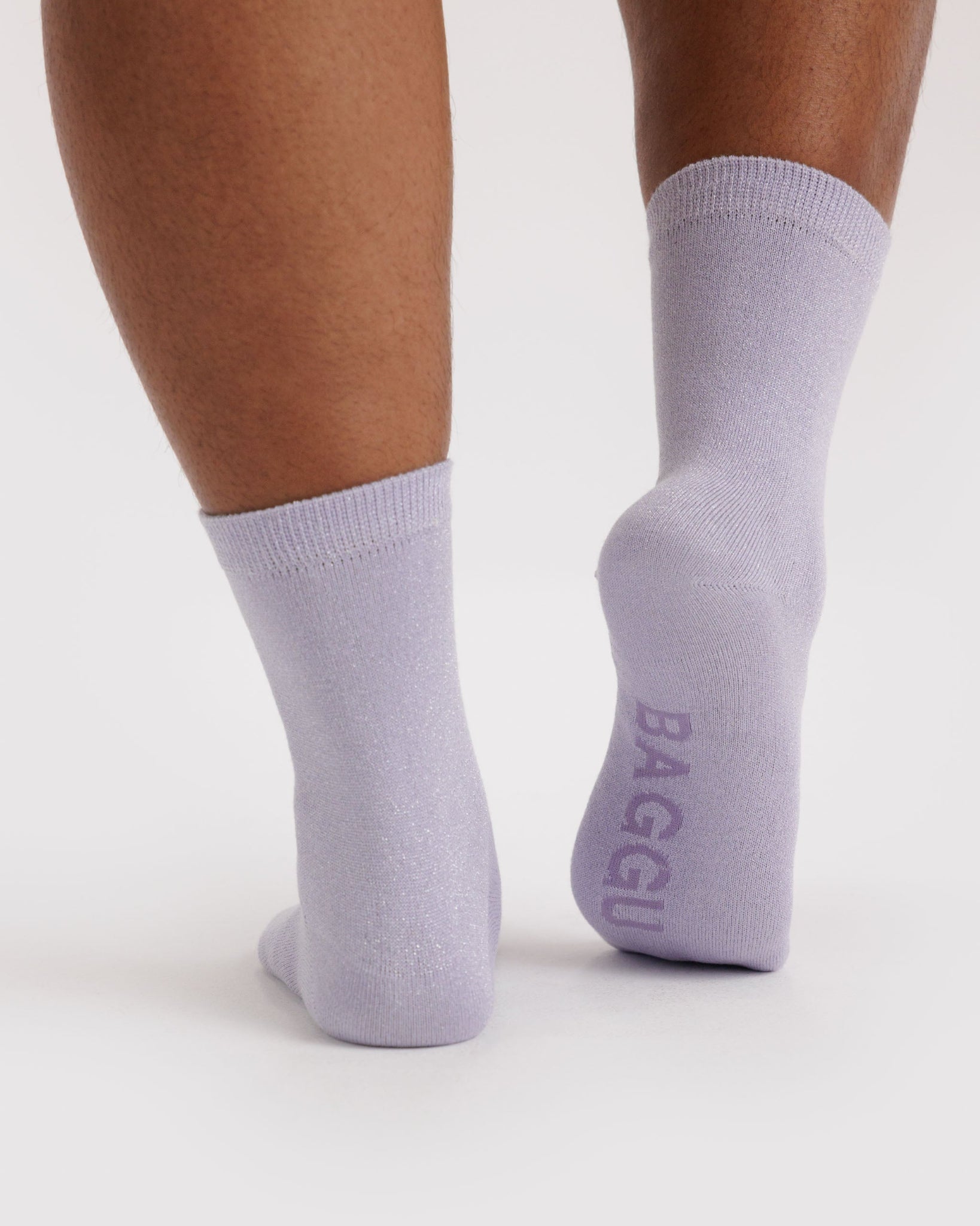 Person wearing light purple socks with 'BAGGU' branding on sole.