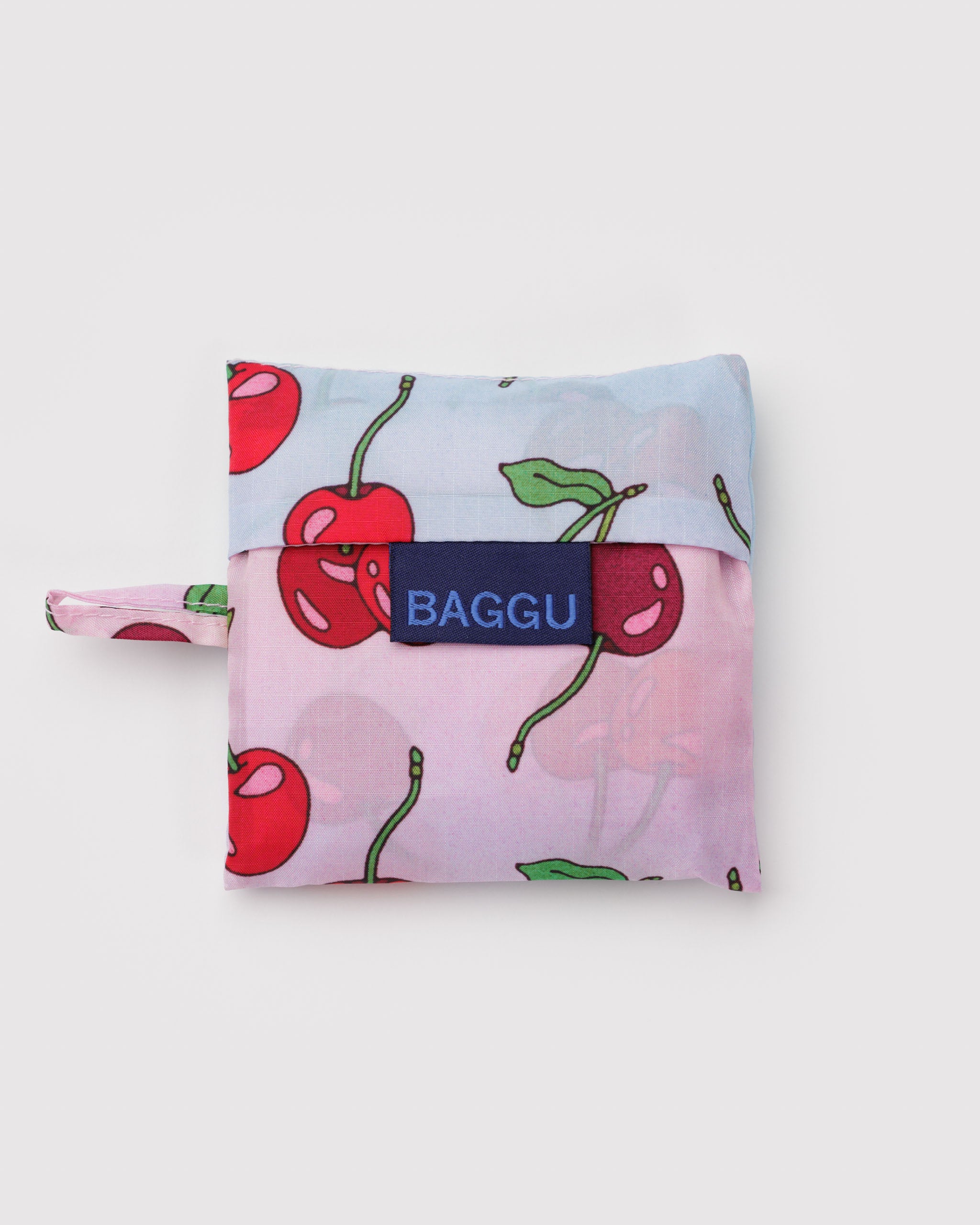 Pouch with cherry design, 'BAGGU' branding tag and hanging loop at the side.