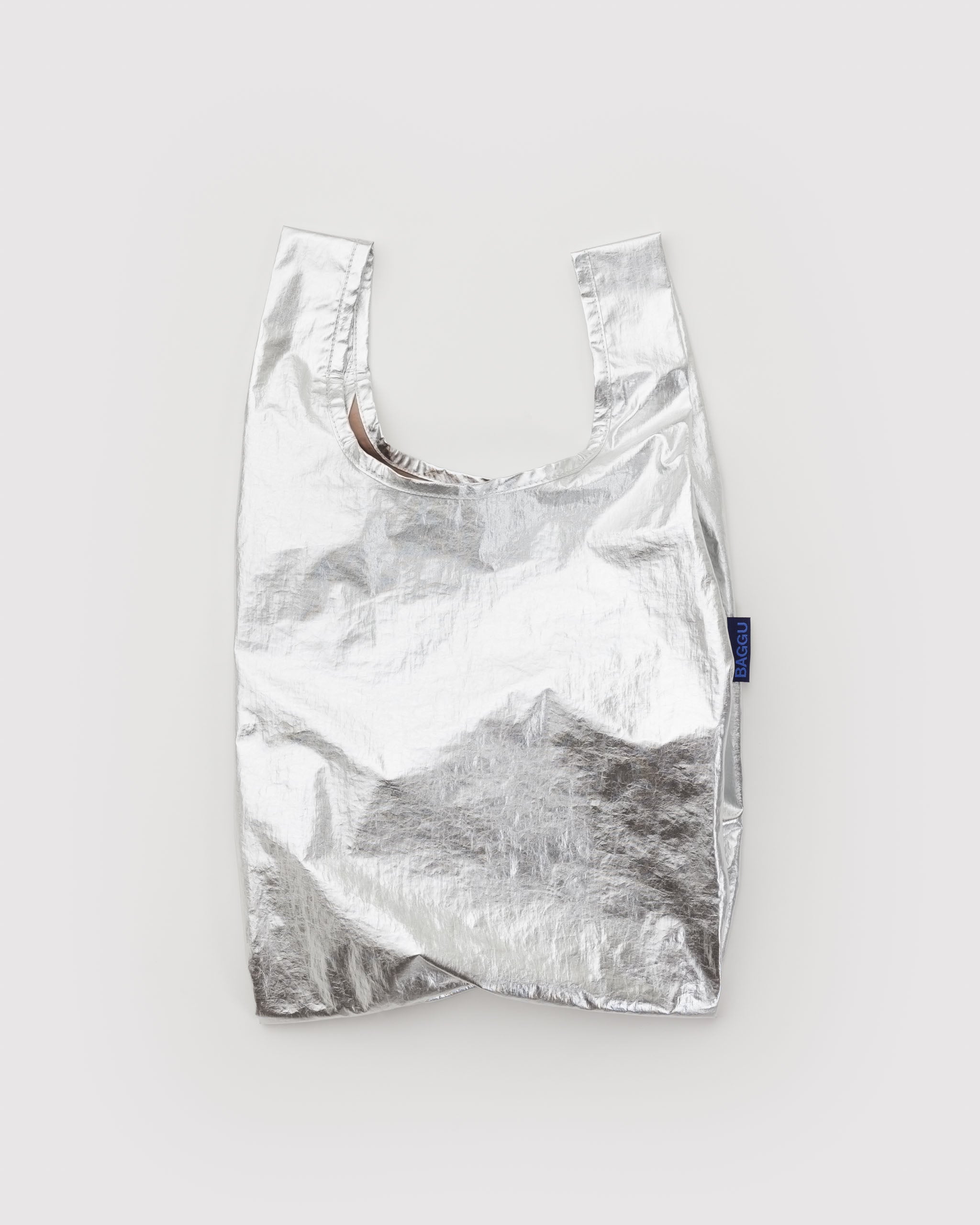 Chrome metallic reflective shopping bag with BAGGU label at side.