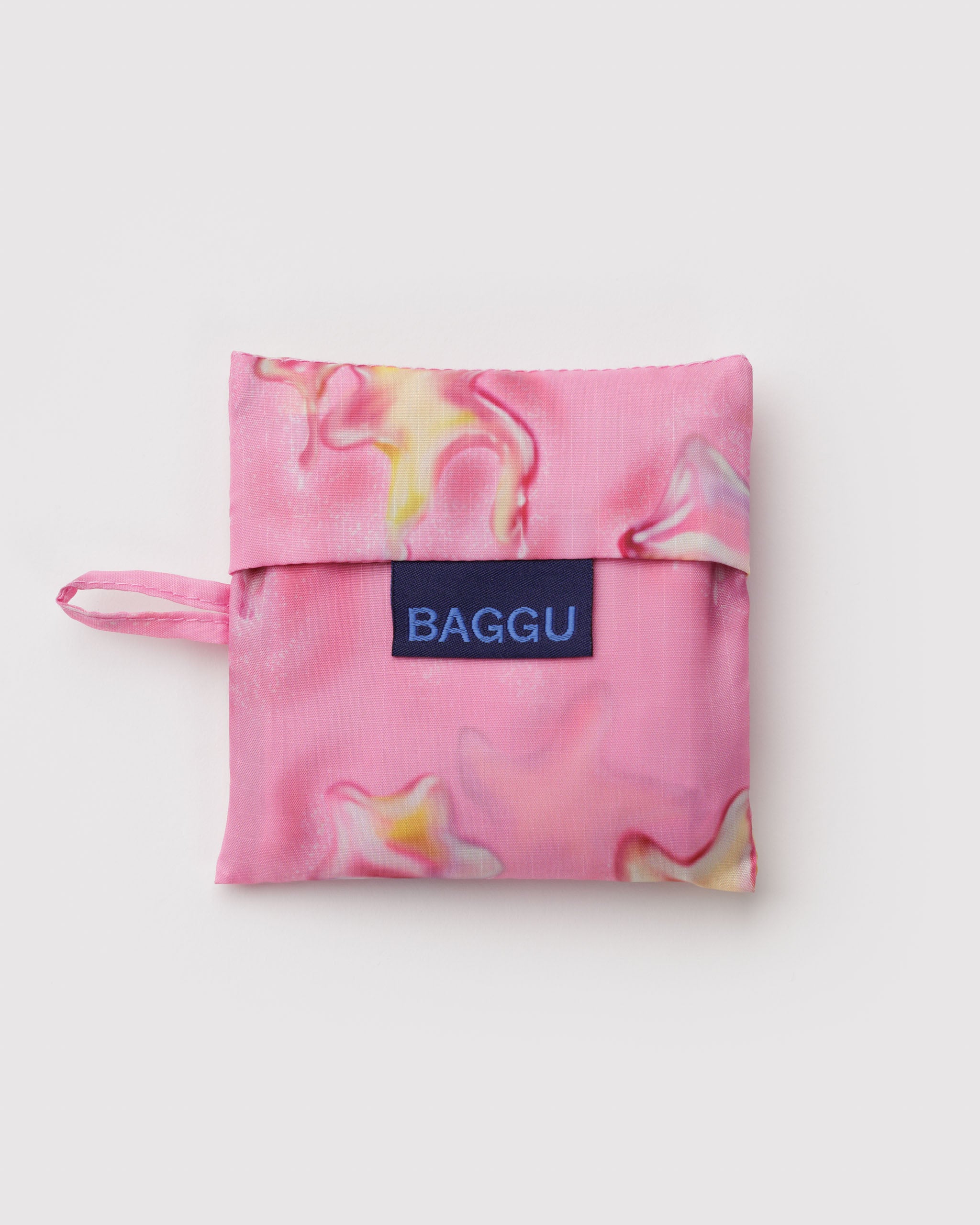 Pink and yellow melting star patterned folded bag with 'BAGGU' label and hanging loop.