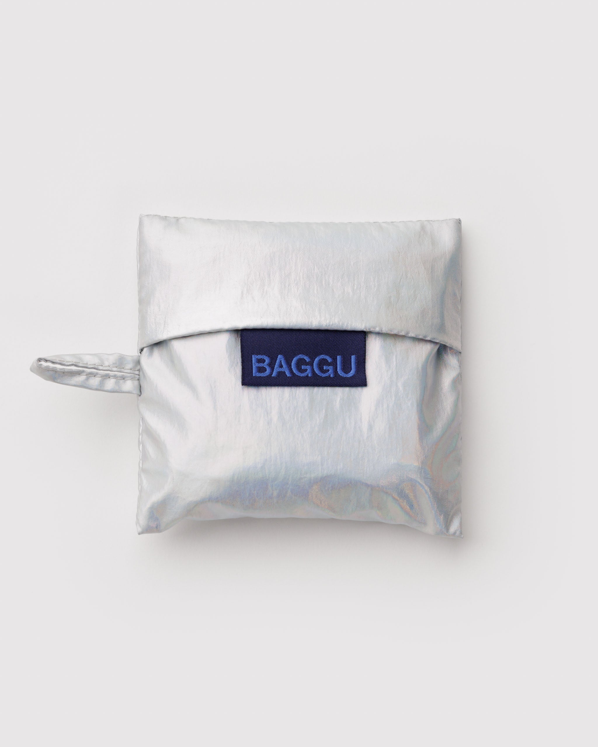 Metallic silver grey reusable pouch with 'BAGGU' logo and hanging loop with a baby baggu folded inside.
