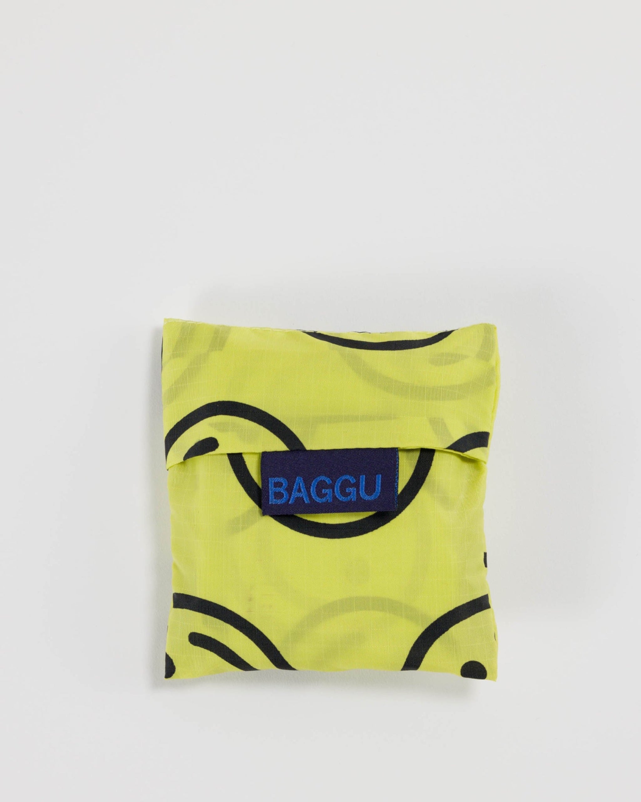 Yellow reusable bag with black patterns and 'BAGGU' logo.