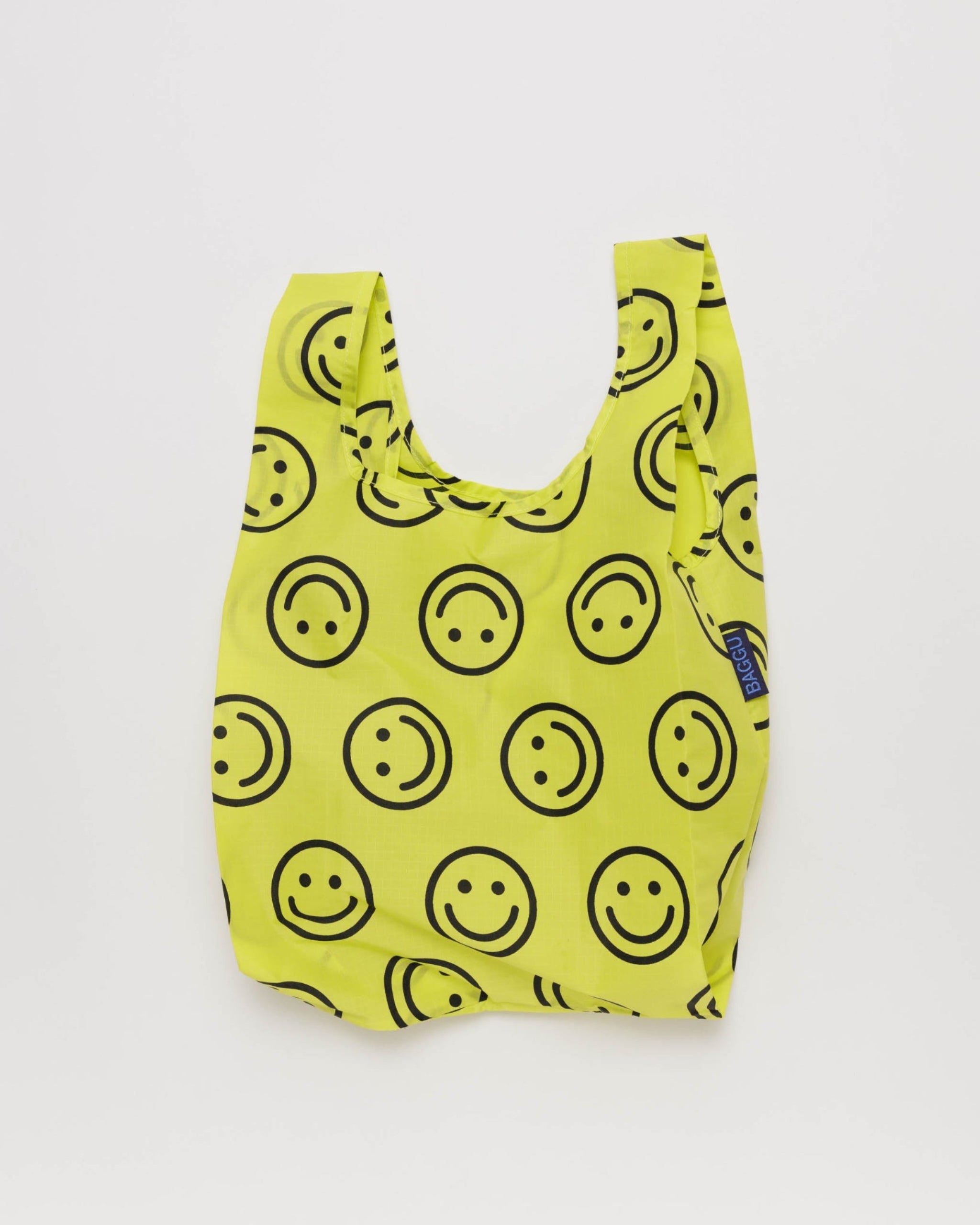 Yellow reusable bag with black smiley face pattern.