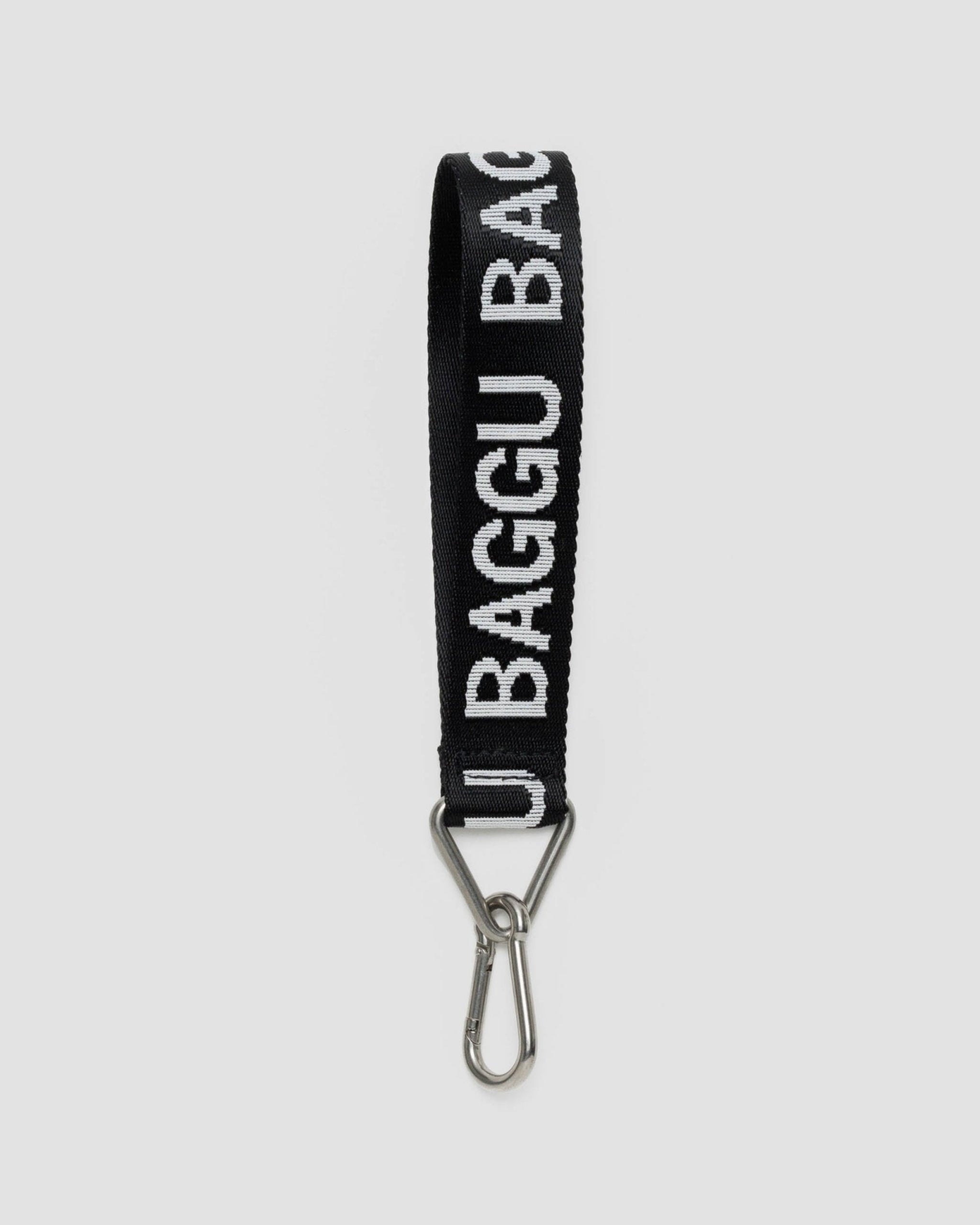 Black webbing strap with a white 'Baggu' Logo woven in attached to an aluminium carabiner of a metal triangular ring and clip.