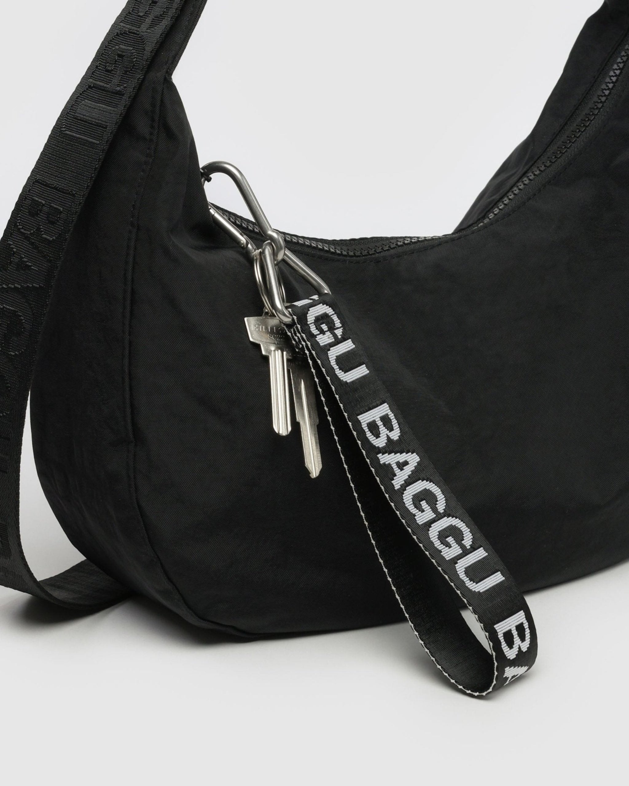 Black and white Baggu Logo Keychain with keys attached to a black crescent bag zip - ANNIE.G