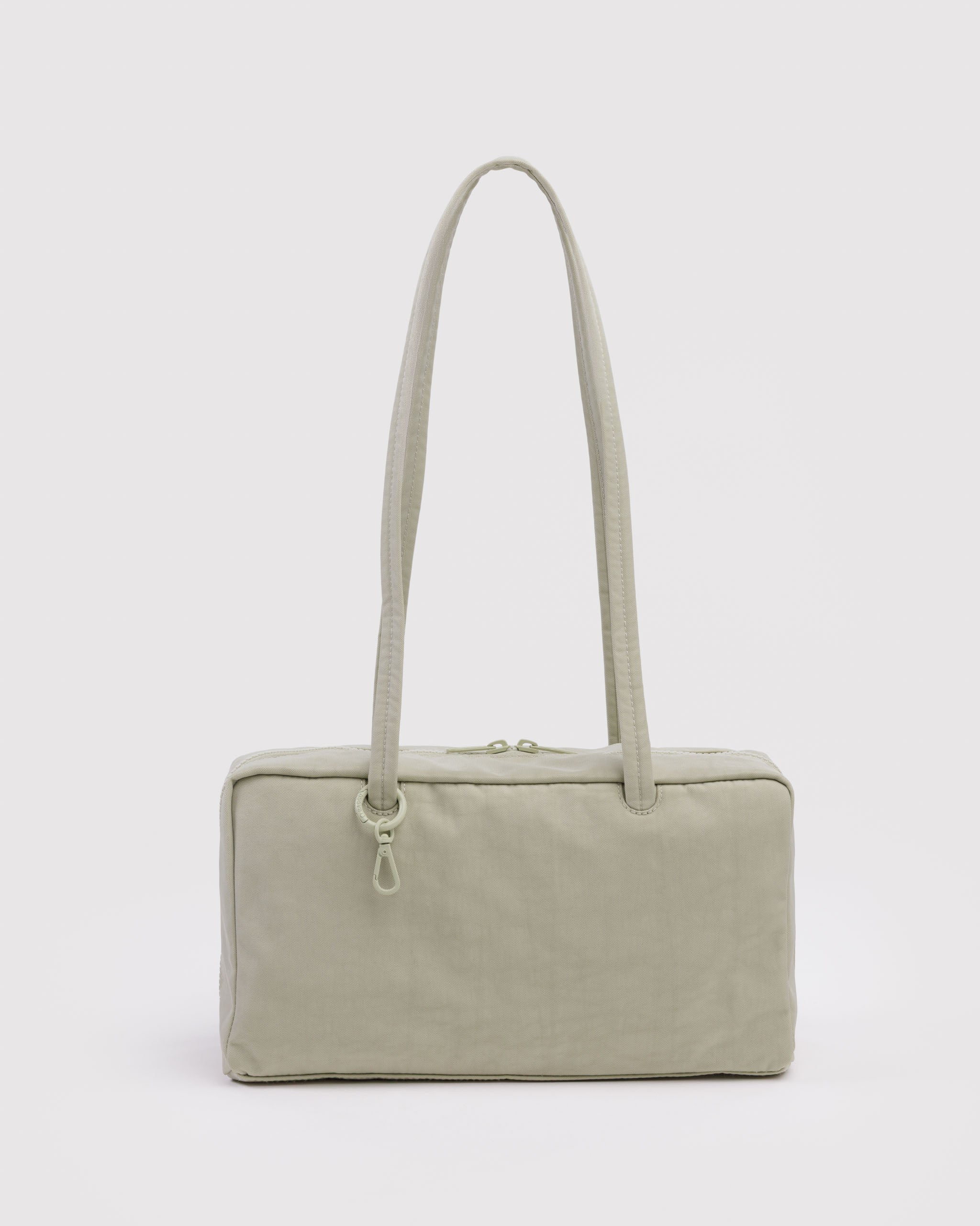 Light green handbag with double carry handles, top double zips and tonal ring with a clip.