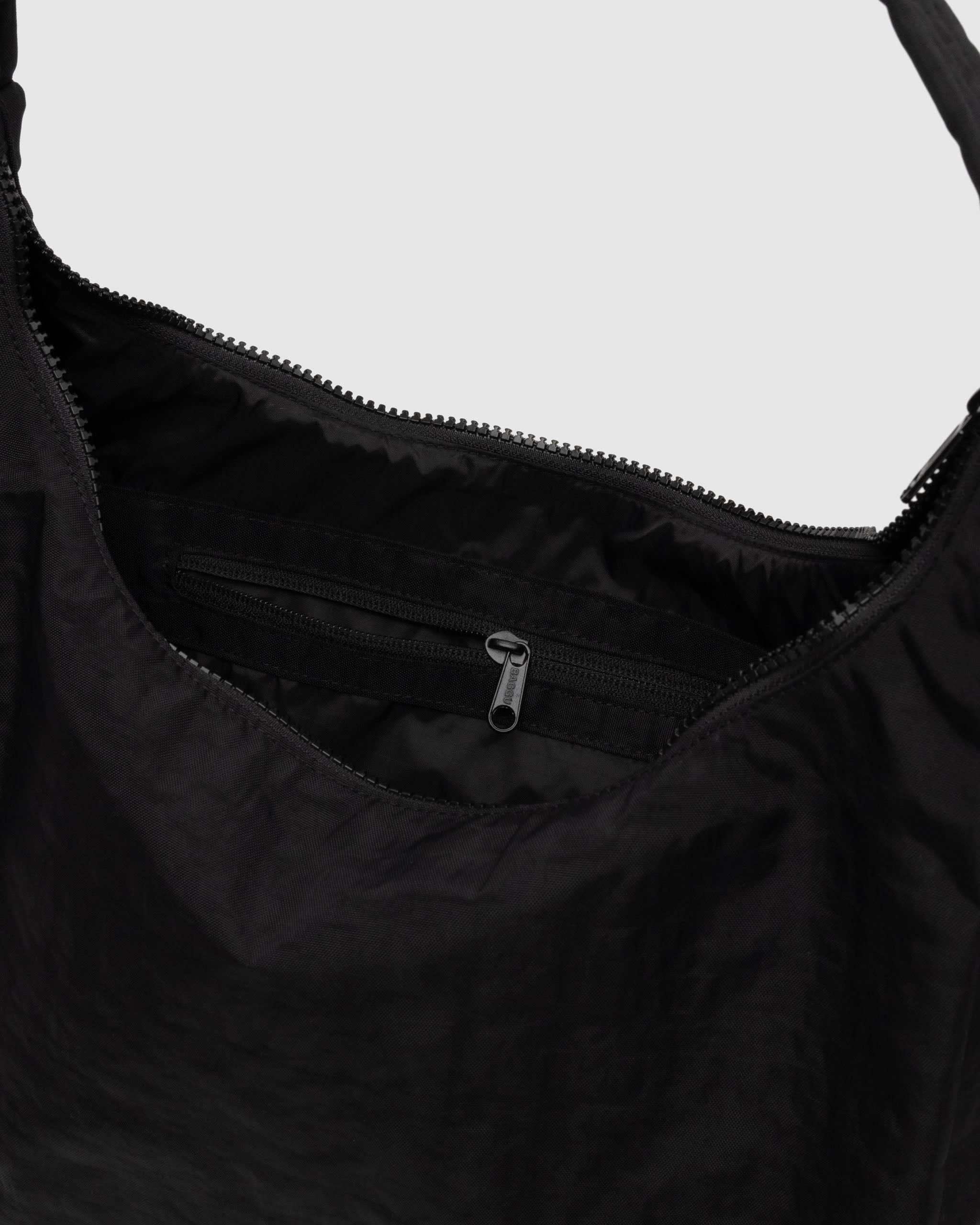 Close-up of a black zipper open on a bag with an internal zip pocket.