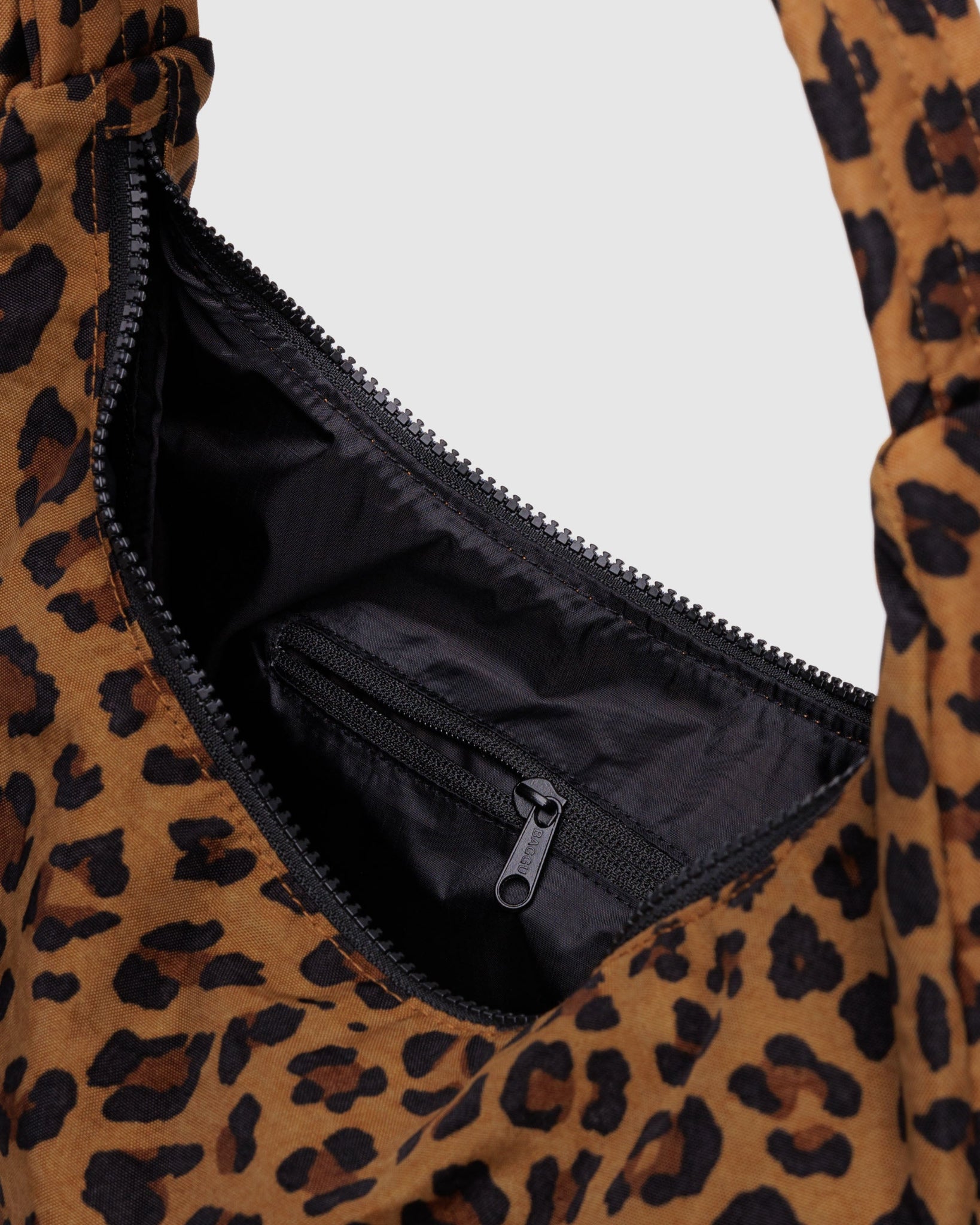 Leopard print bag with open zipper pocket showing black lining and internal zip pocket.