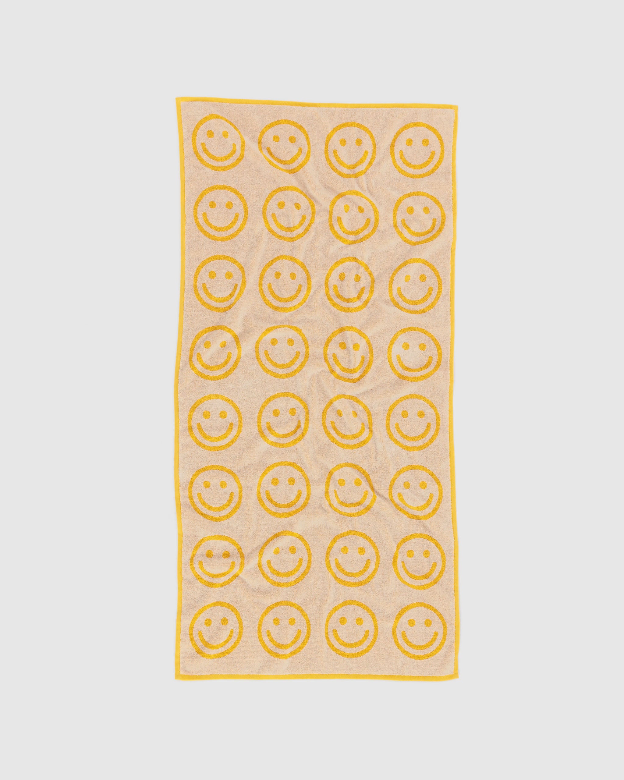 light yellow towel with yellow smiley face patterns.