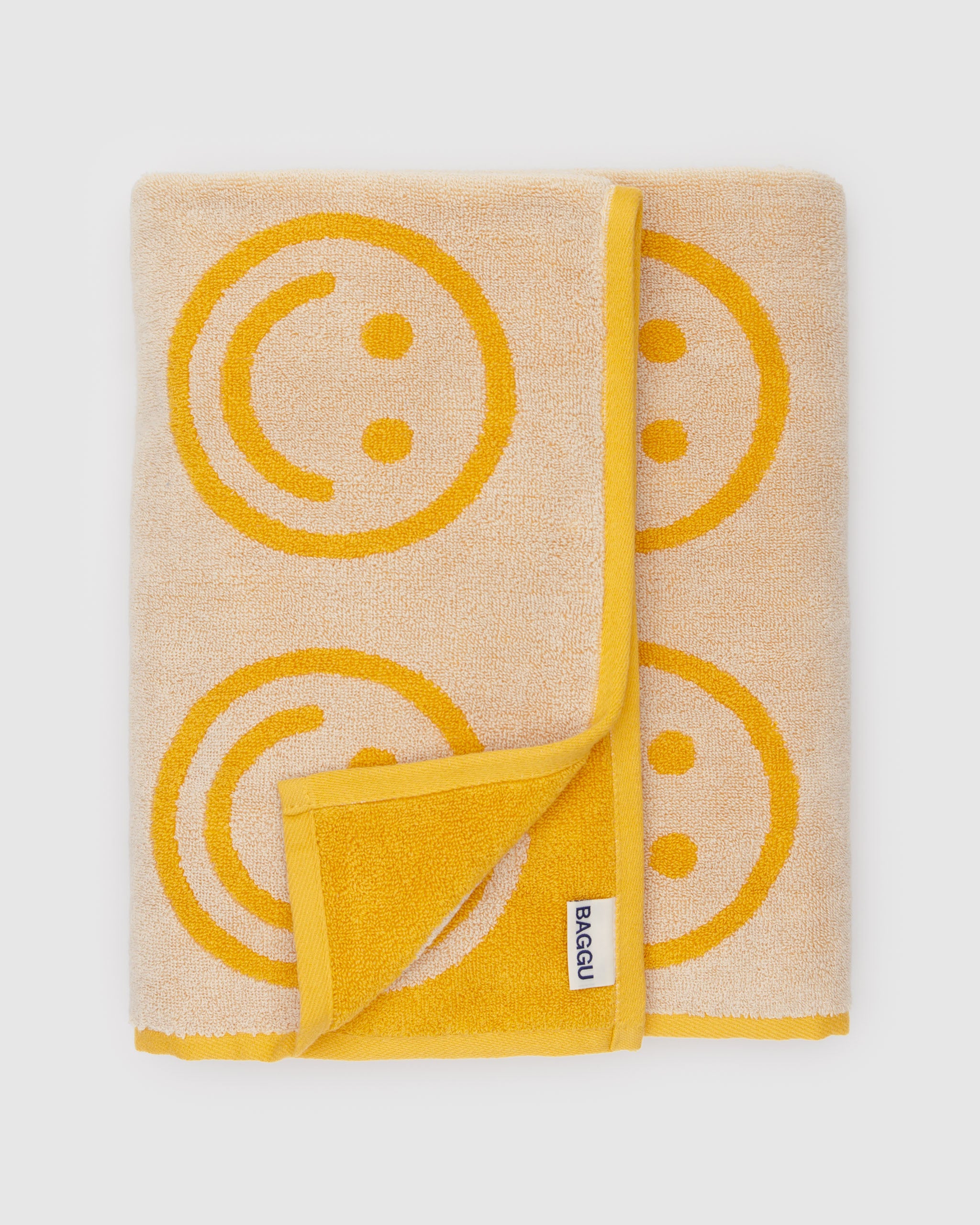 Yellow towel with yellow smiley face patterns.