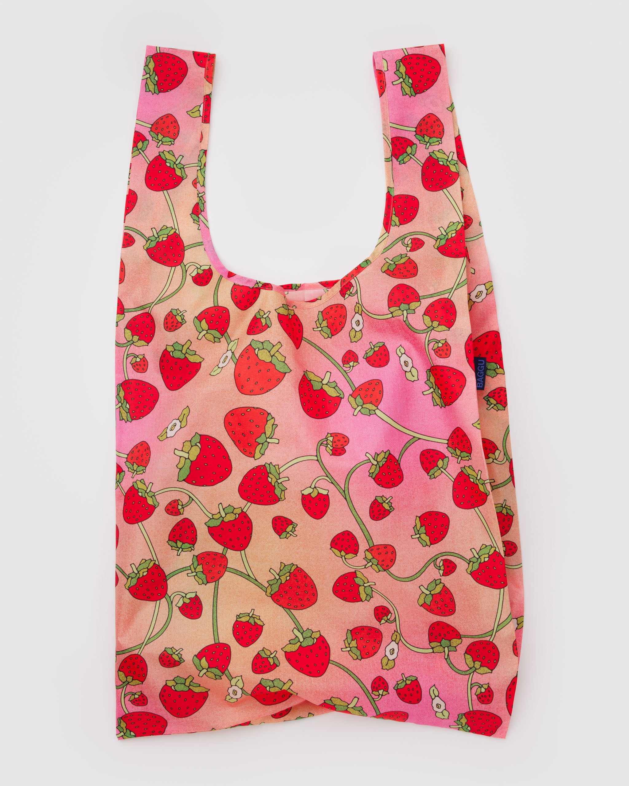Reusable tote bag with strawberry and white blossoms pattern.