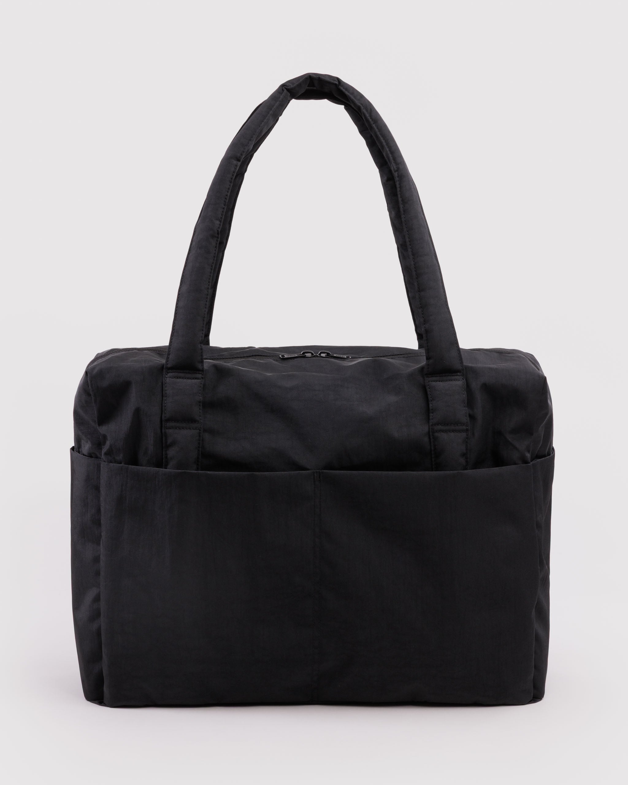 Black tote bag with carry handles, zip top closure and exterior pockets.