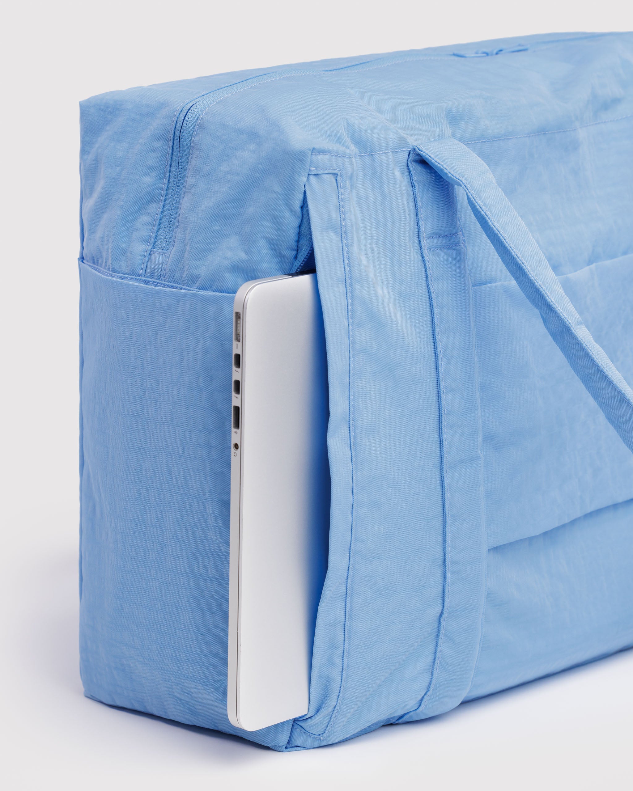 Blue duffle bag with a side zip compartment for a laptop.