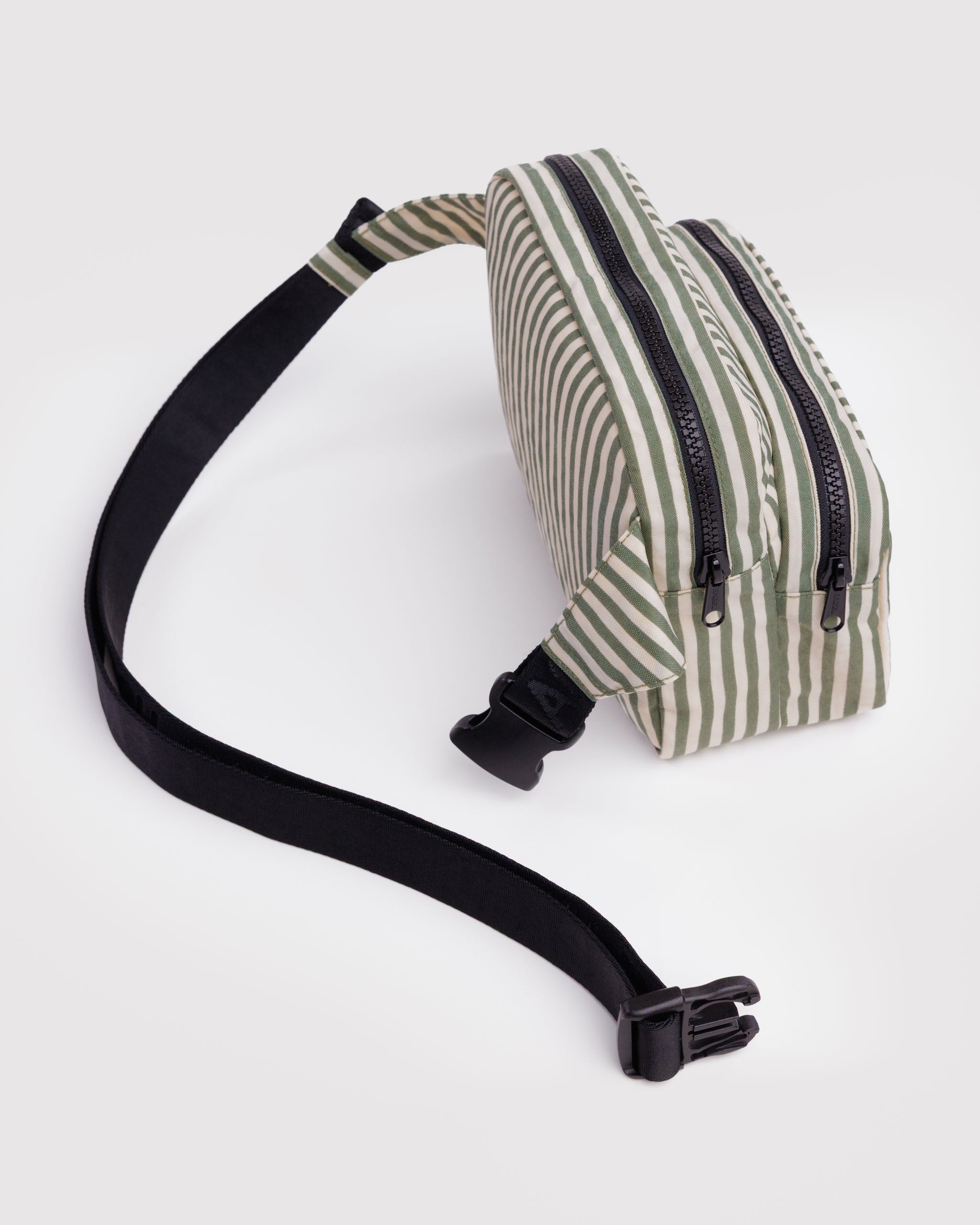 Striped green and cream waist bag with an adjustable black webbed strap with clip open and two main compartments.