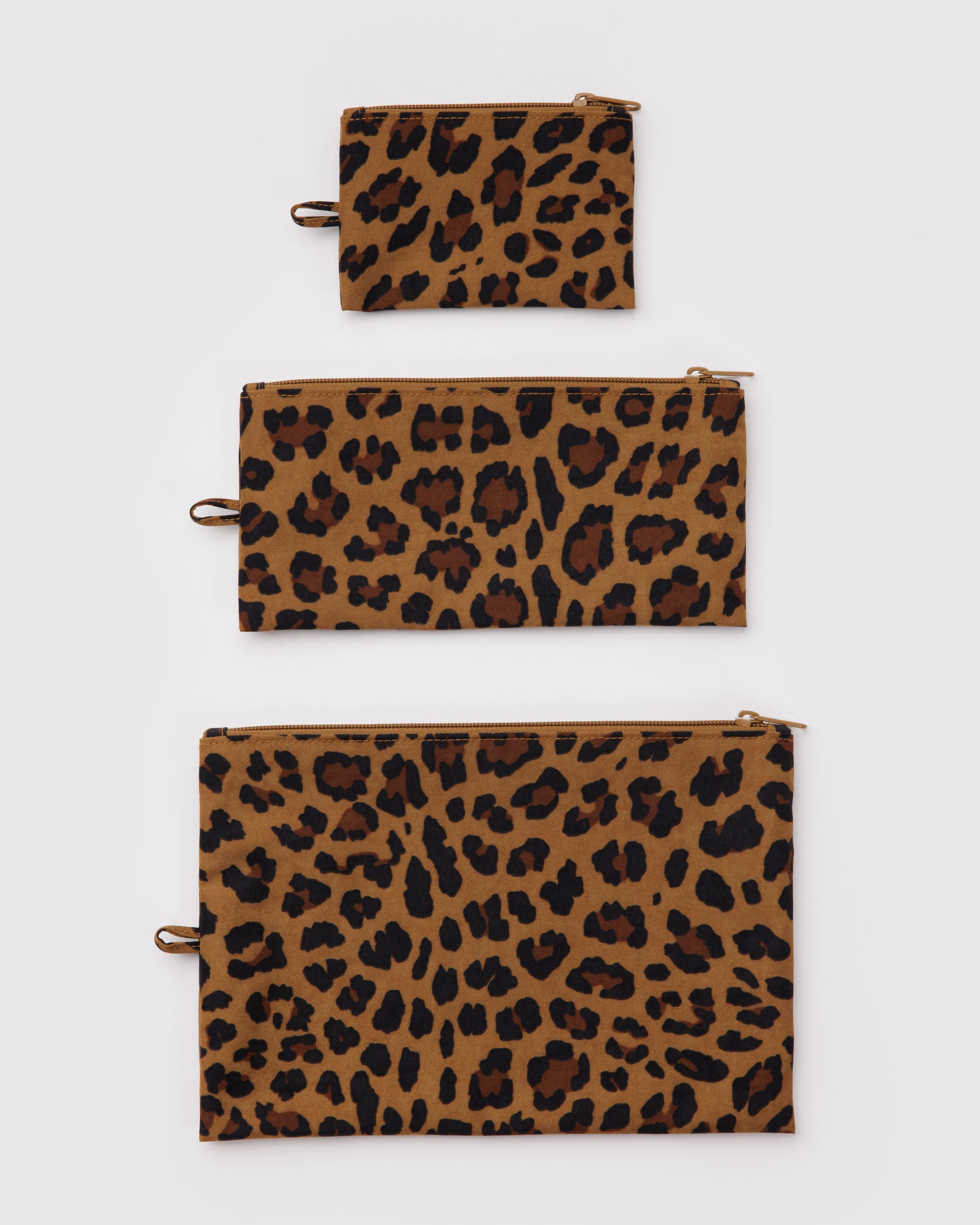 Set of three flat, different sized leopard print, zip top pouches with a hanging loop at the side.