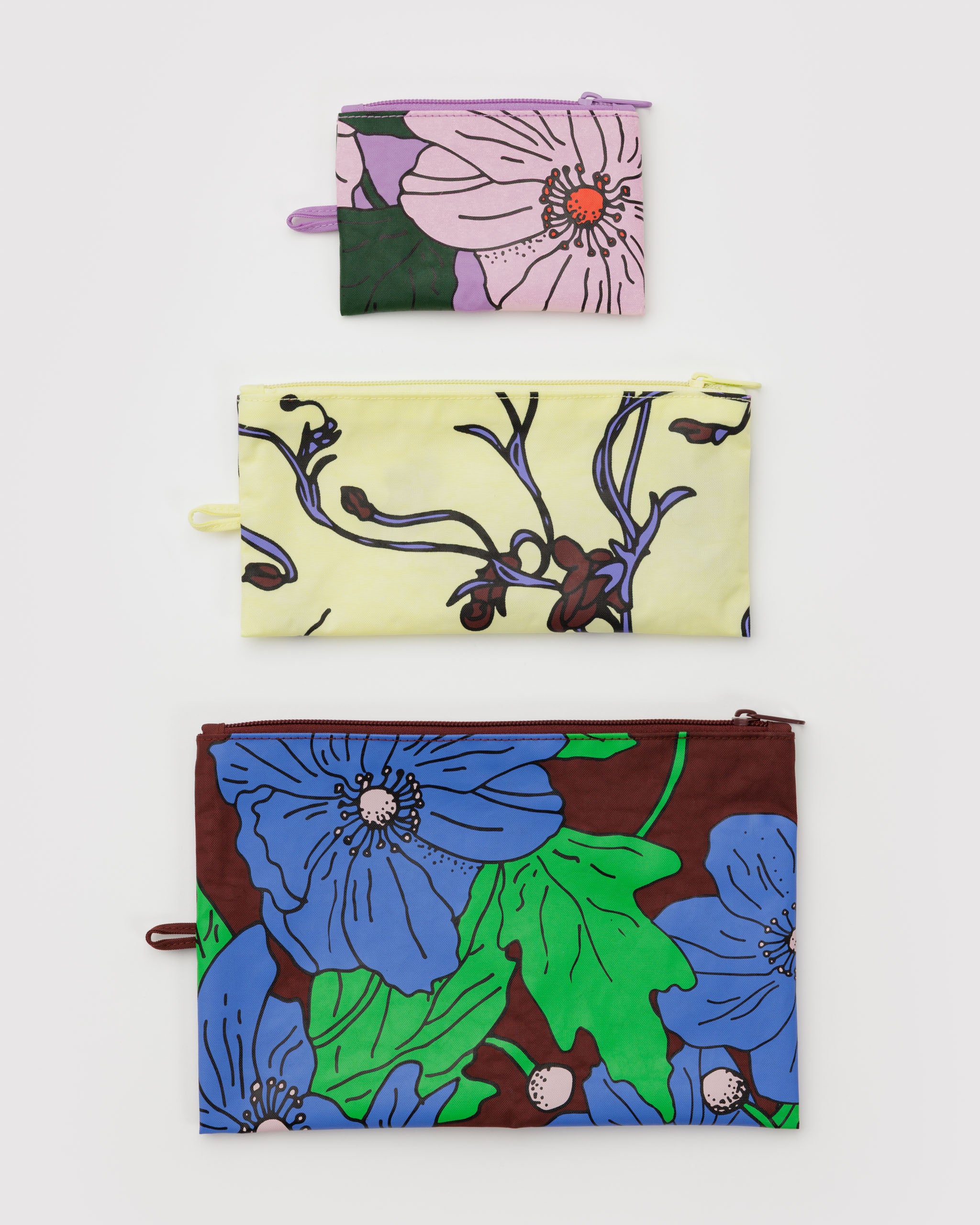 Three floral-patterned zip pouches lying flat.