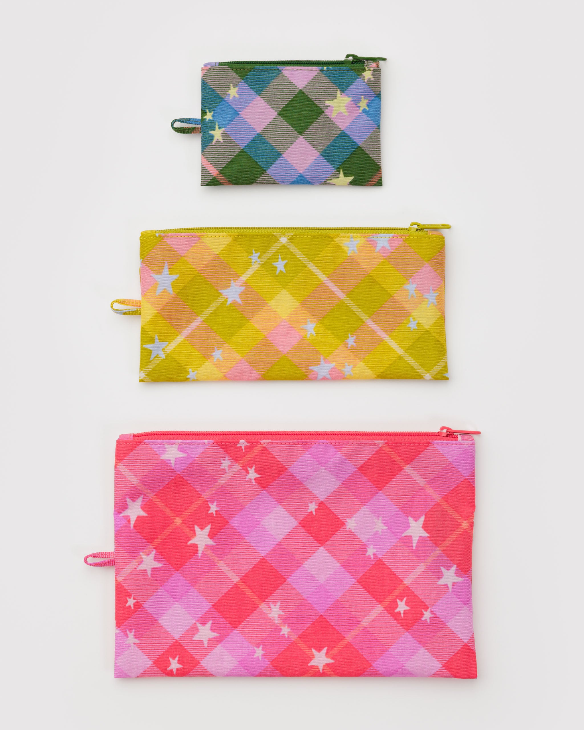 Three different sized zippered colourful plaid patterned pouches with stars in green, yellow and pink with a hanging loop.