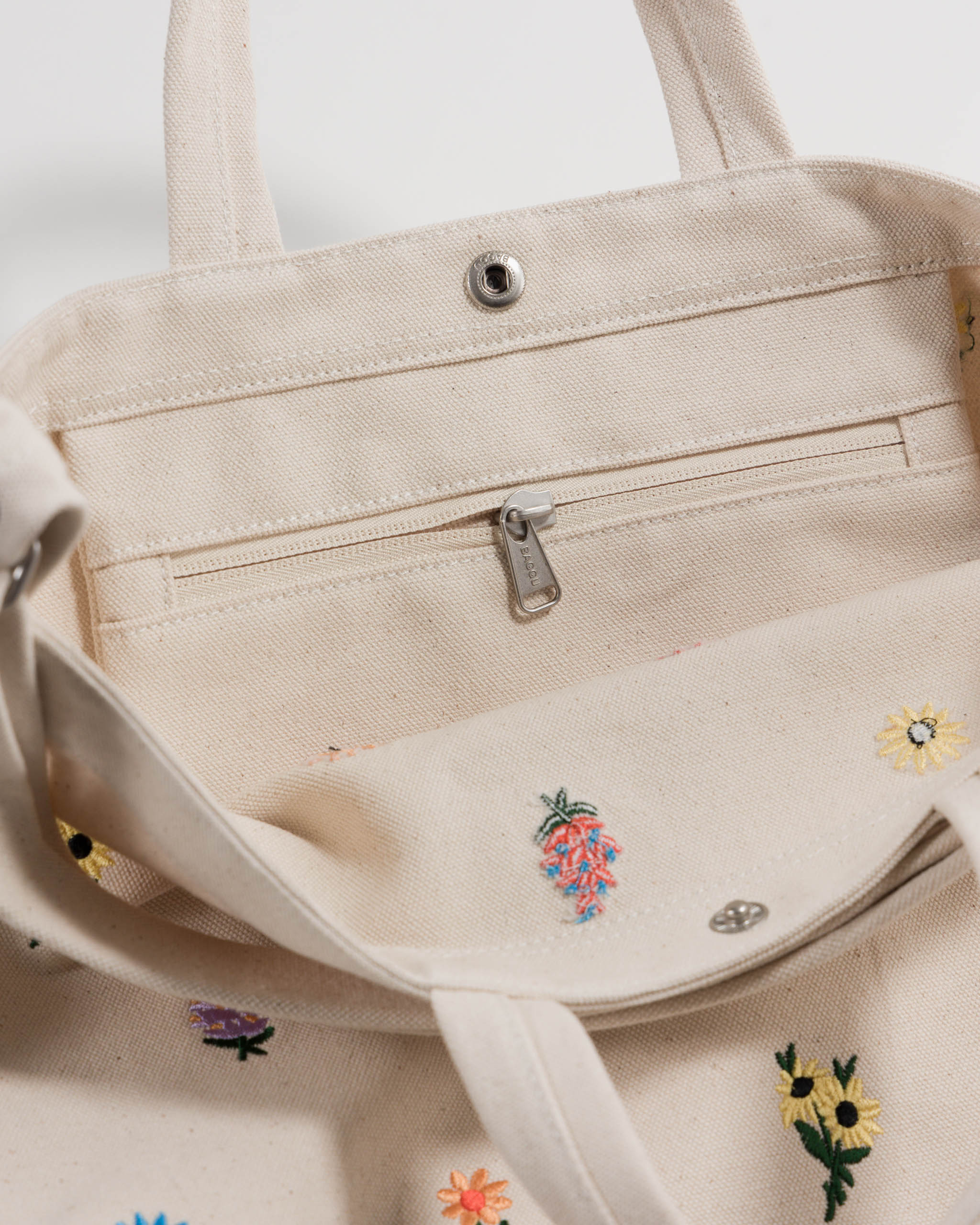 inside-zip-pocket-of-embroidered-floral-canvas-tote-bag-with-short-handles-and-long-adjustable-strap