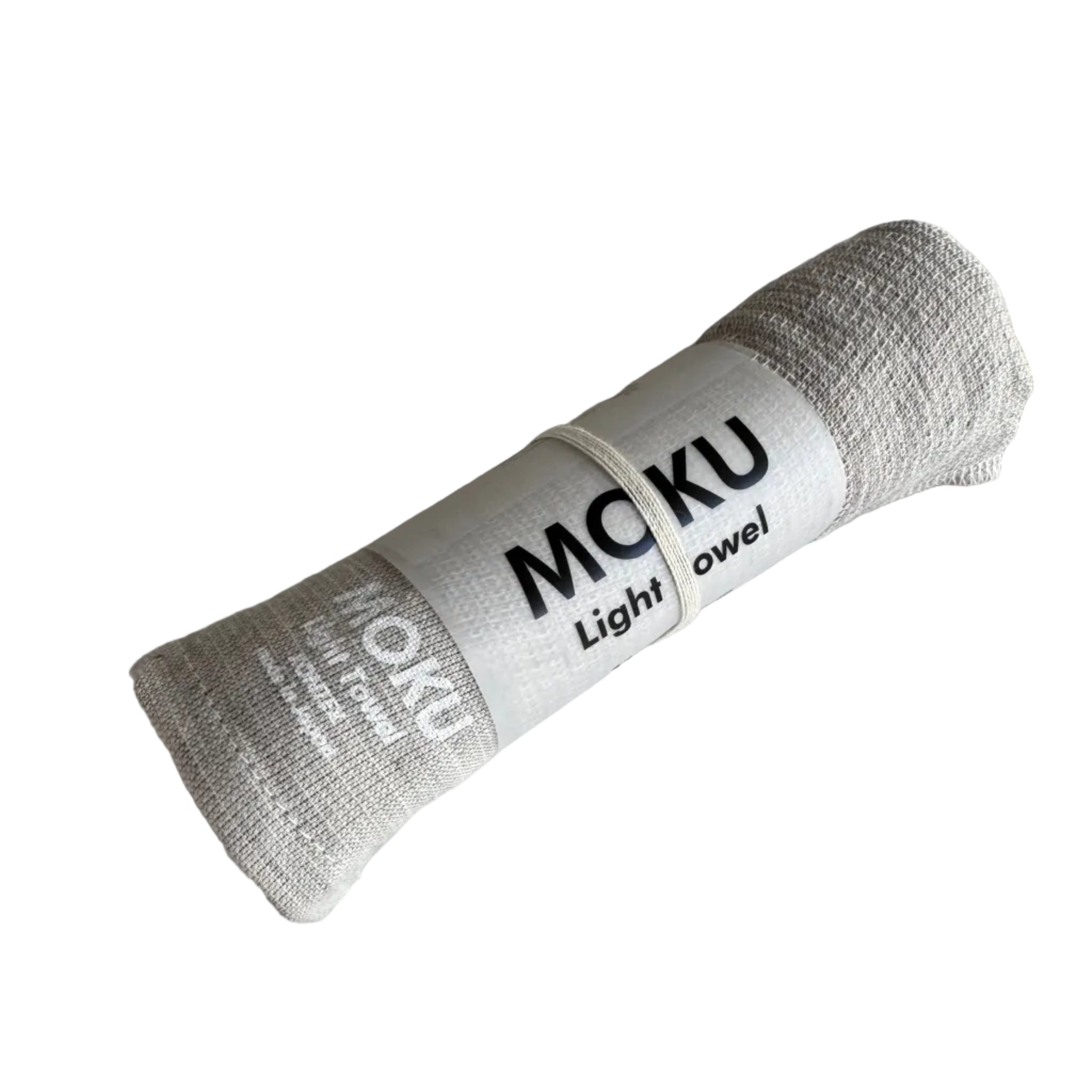 Natural coloured towel rolled in packaging sleeve with "MOKU Light Towel' written in white on fabric.