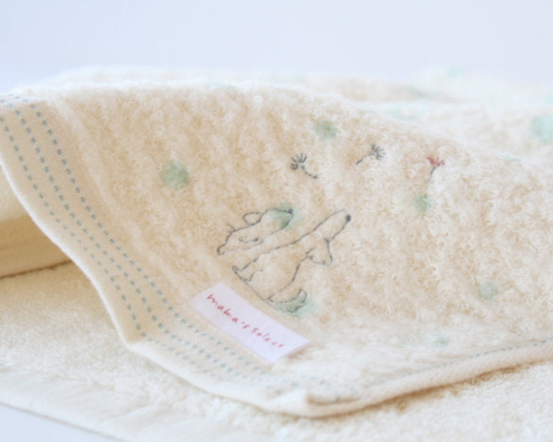 Child's hooded cream towel with dog embroidered design and mint blue polka dots.