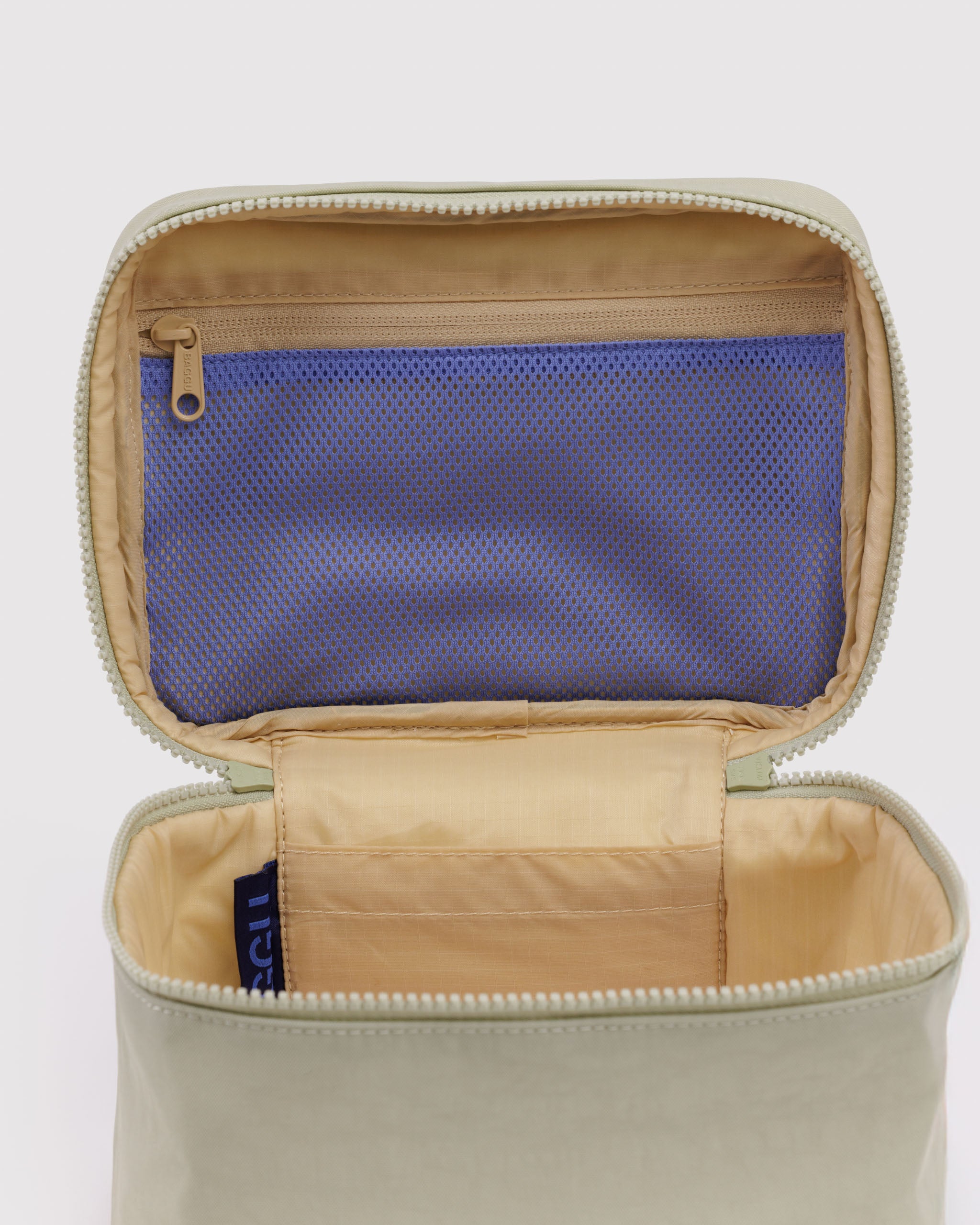 Open light green cosmetic case with a blue mesh interior zip pocket on lid.