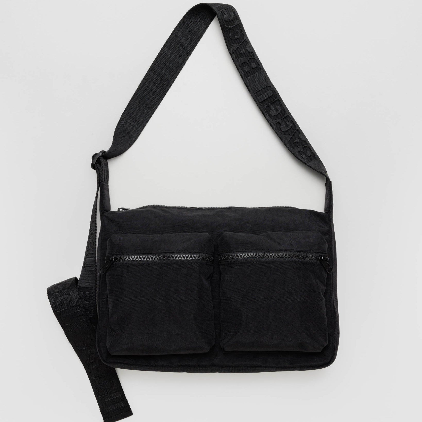 A black medium cargo crossbody bag with an adjustable strap, zippered closures, and multiple compartments.