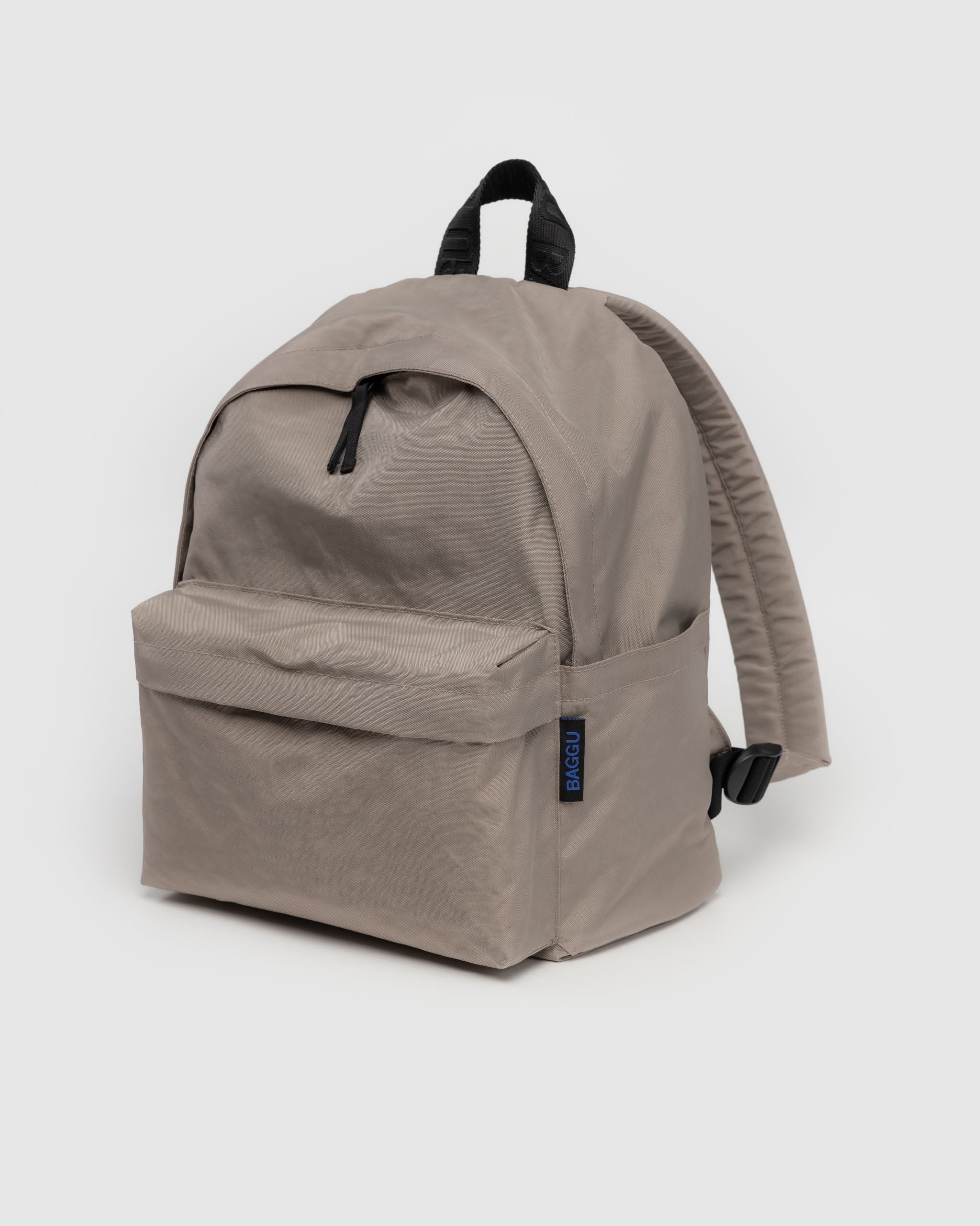 Light grey backpack with top zip closure, front zip pocket, top black carry handle and tonal quilted adjustable back straps