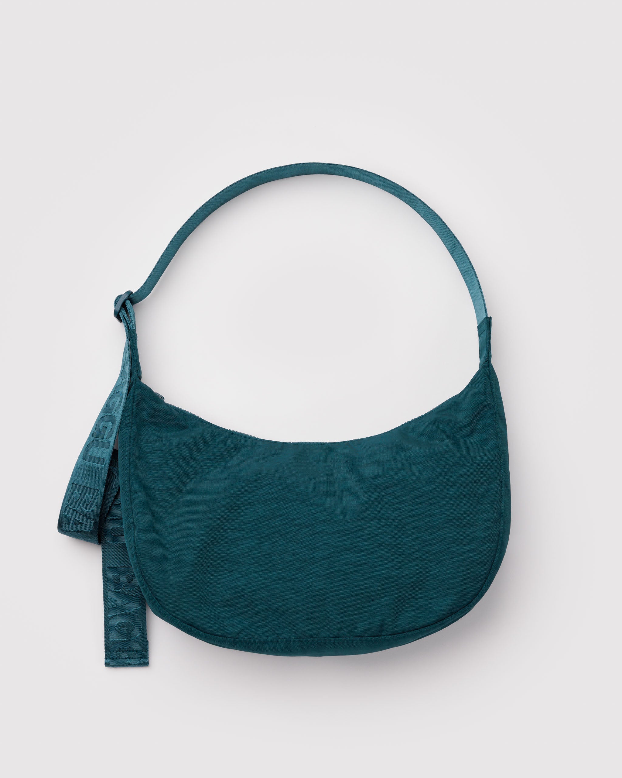 Teal shoulder bag in a crescent shape with a long wide webbed adjustable strap and top zip.