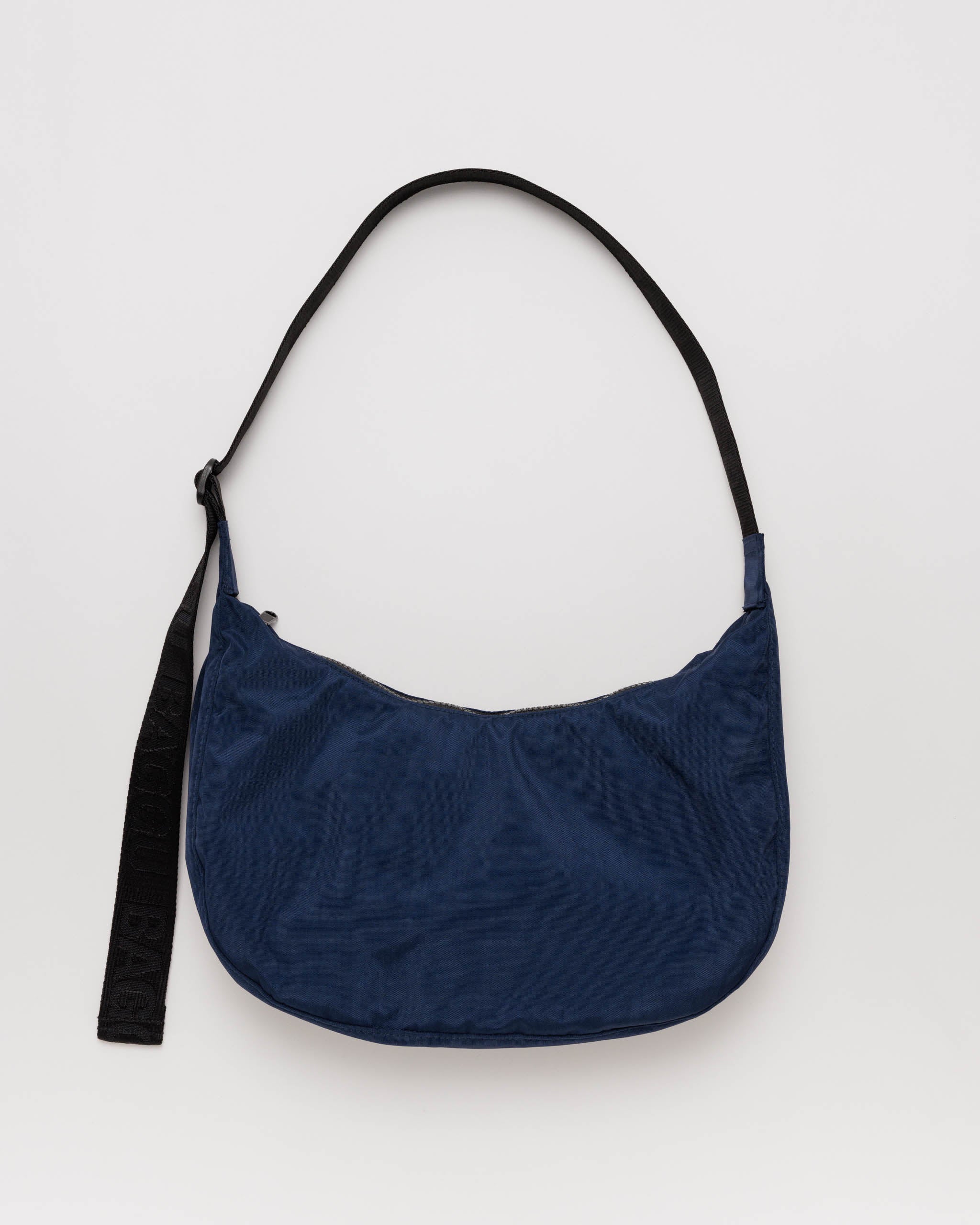 Navy blue handbag with a black adjustable strap