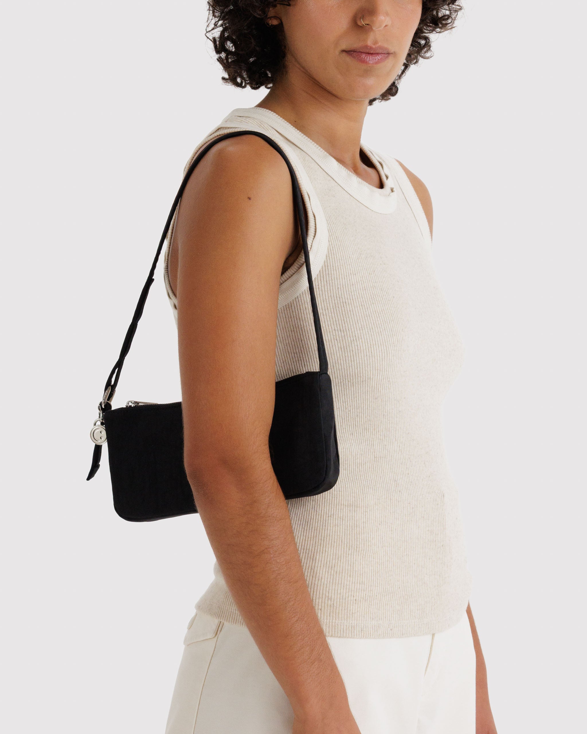 Person wearing a black handbag over one shoulder.
