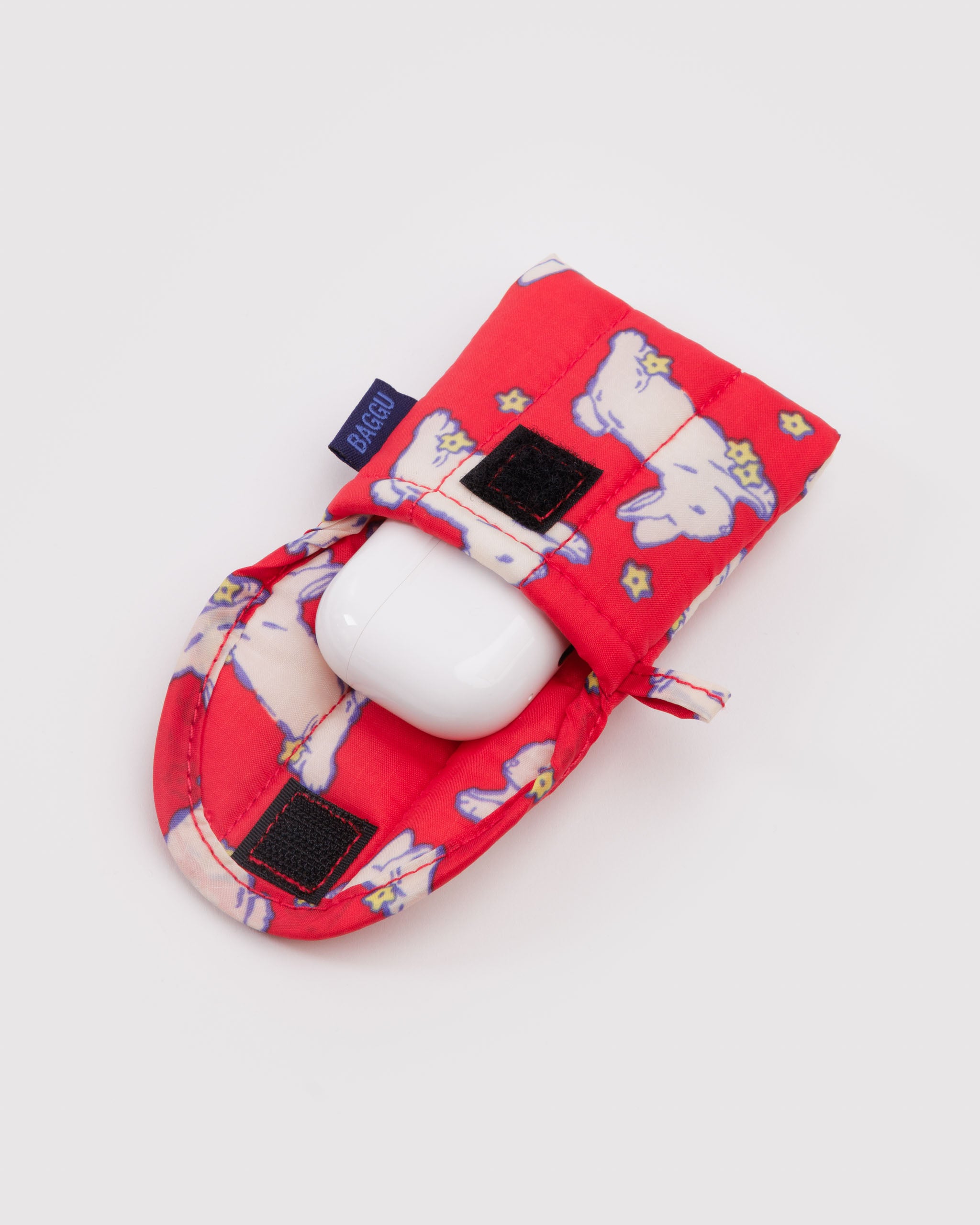 Red pouch with white bunnies design and velcro closure containing a white earbuds case.