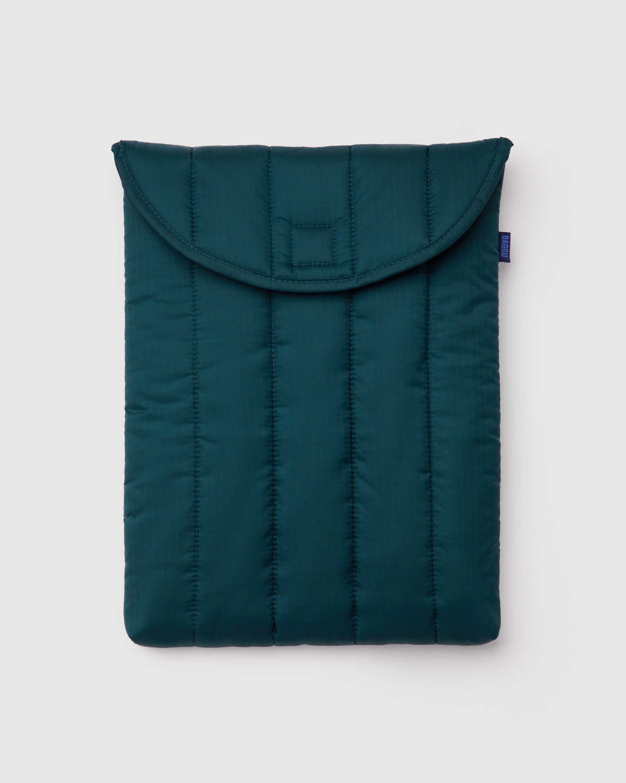 Teal quilted and puffy laptop sleeve with BAGGU logo tag at the side.