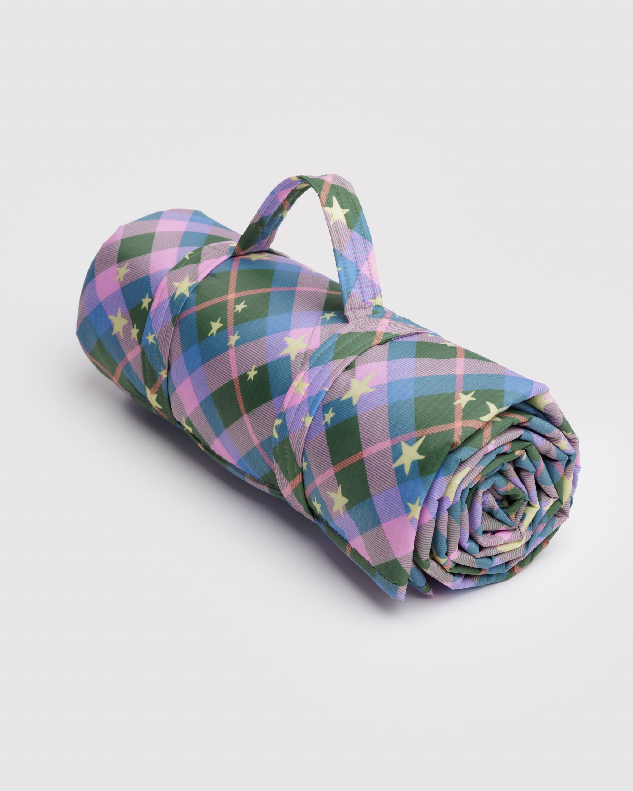 Rolled-up quilted picnic blanket with a carry handle in colourful green plaid pattern.