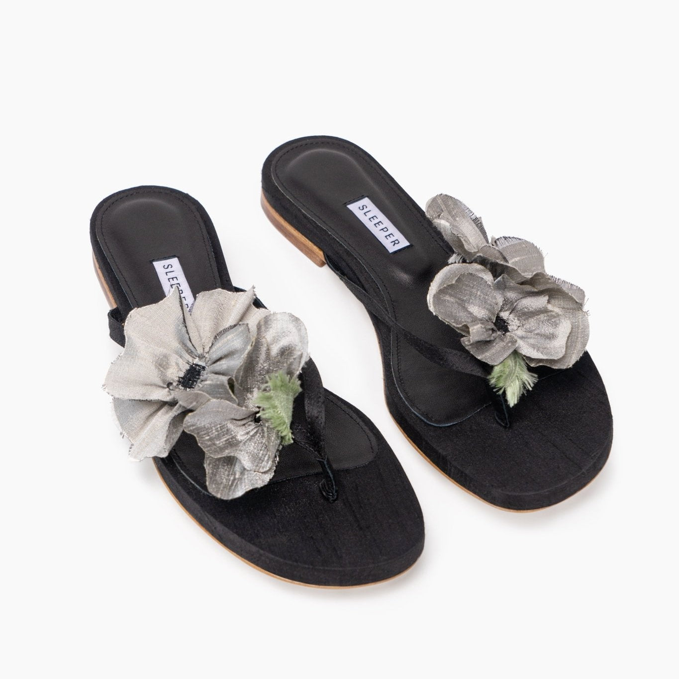 Pair of black leather slides with grey wild silk poppy flower decoration and white Sleeper brand label.