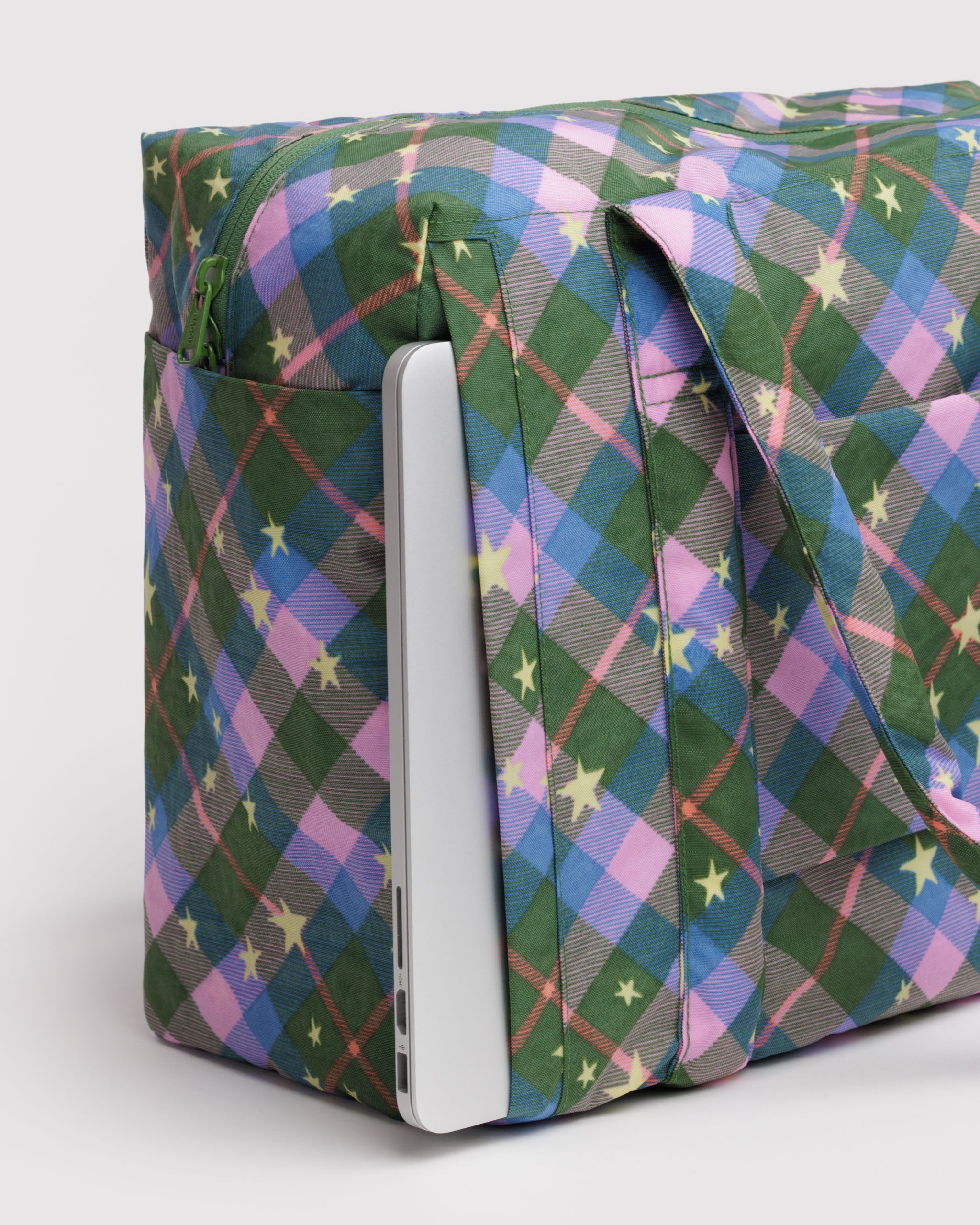 Colorful green plaid patterned bag with a laptop inside side zip pocket.