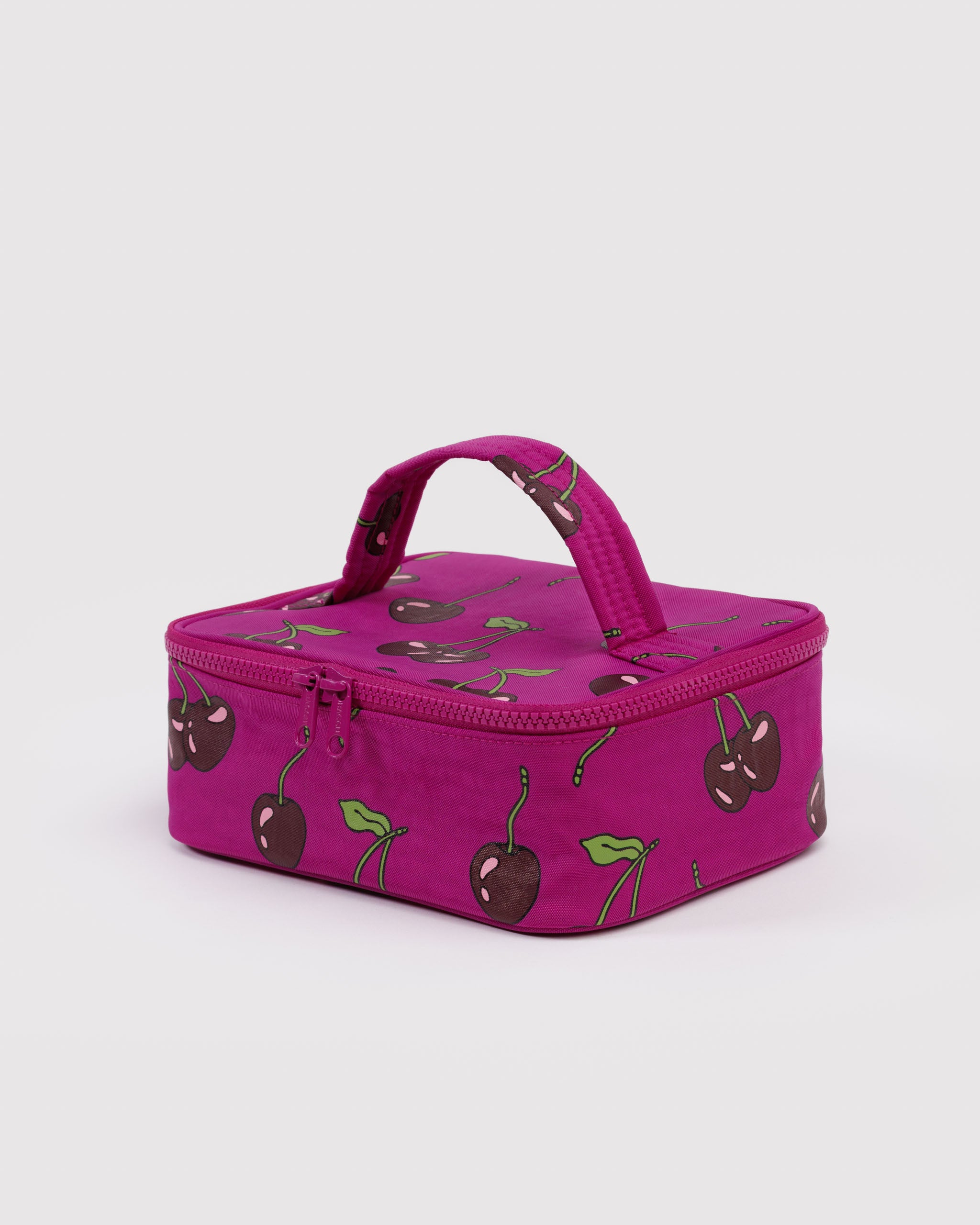 Vibrant pink cosmetic bag with cherry pattern, zip closure and carry handle.