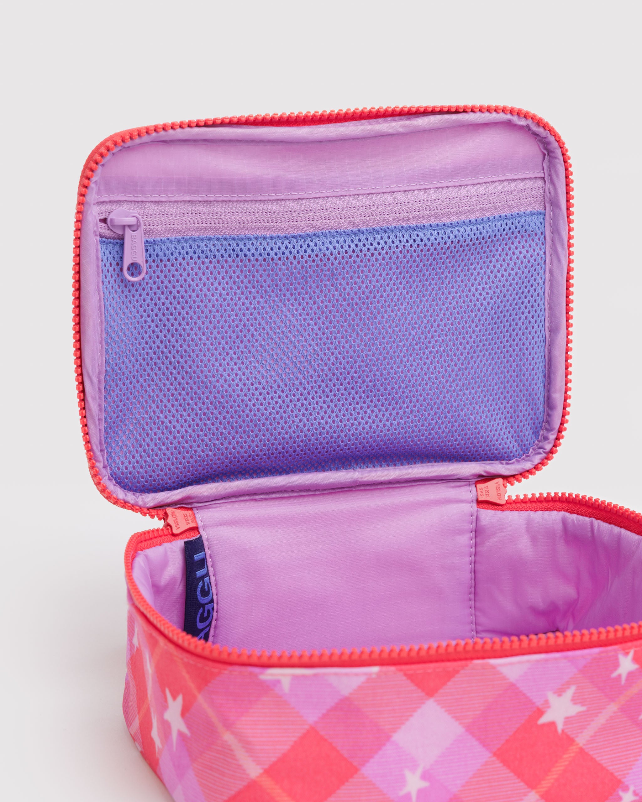 Open zipper lid with a zip mesh pouch on pink and purple plaid with stars print cosmetic bag