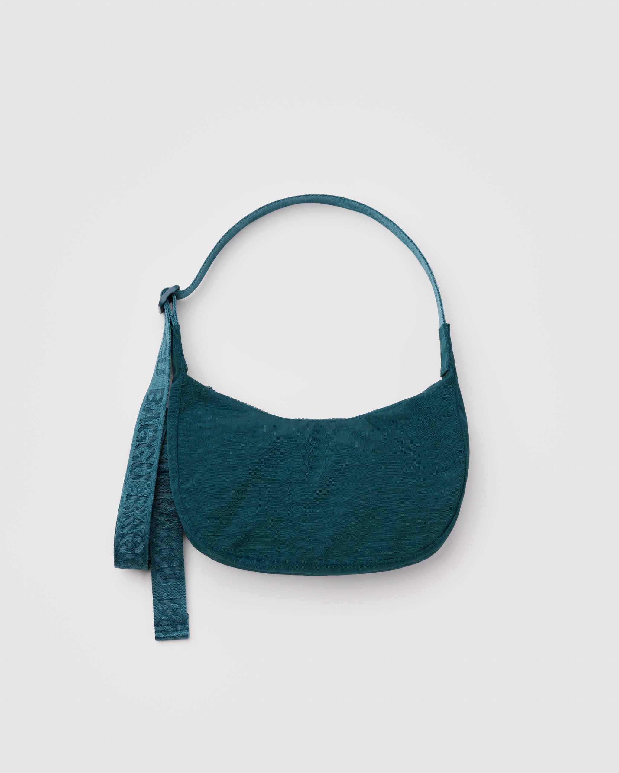 Teal handbag with an adjustable strap with BAGGU branding and a zip top.