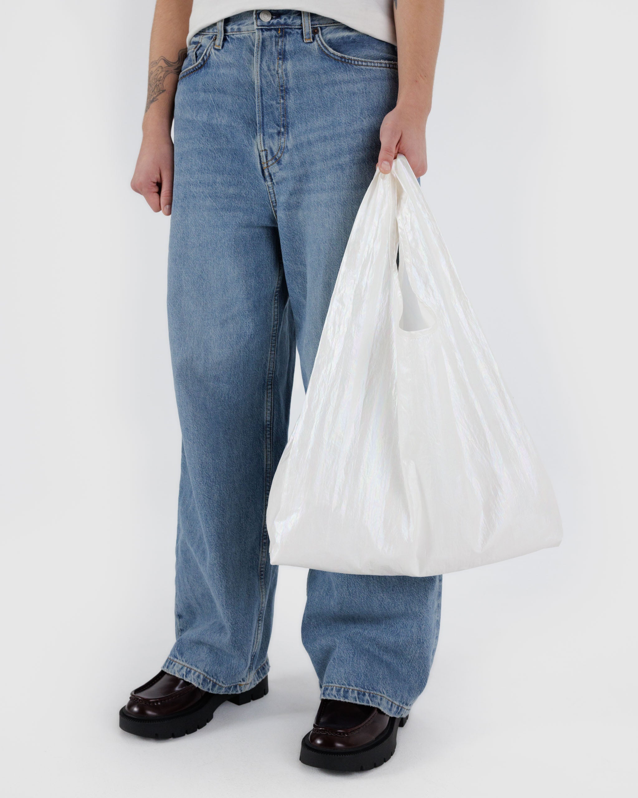 person-holding-handles-of-standard-reusable-bag-pearl-metallic