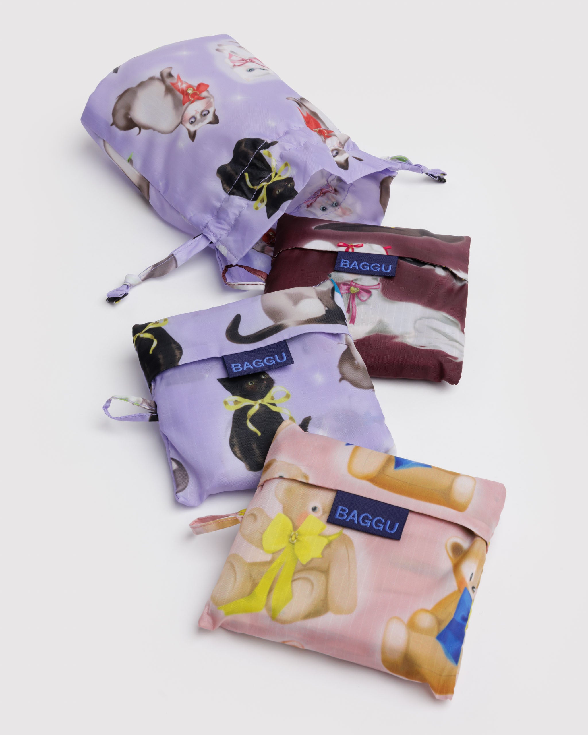 Set of three reusable shopping bags in fancy animal prints of cat, dog and teddy, in their foldable pouch that store inside a matching drawstring pouch.