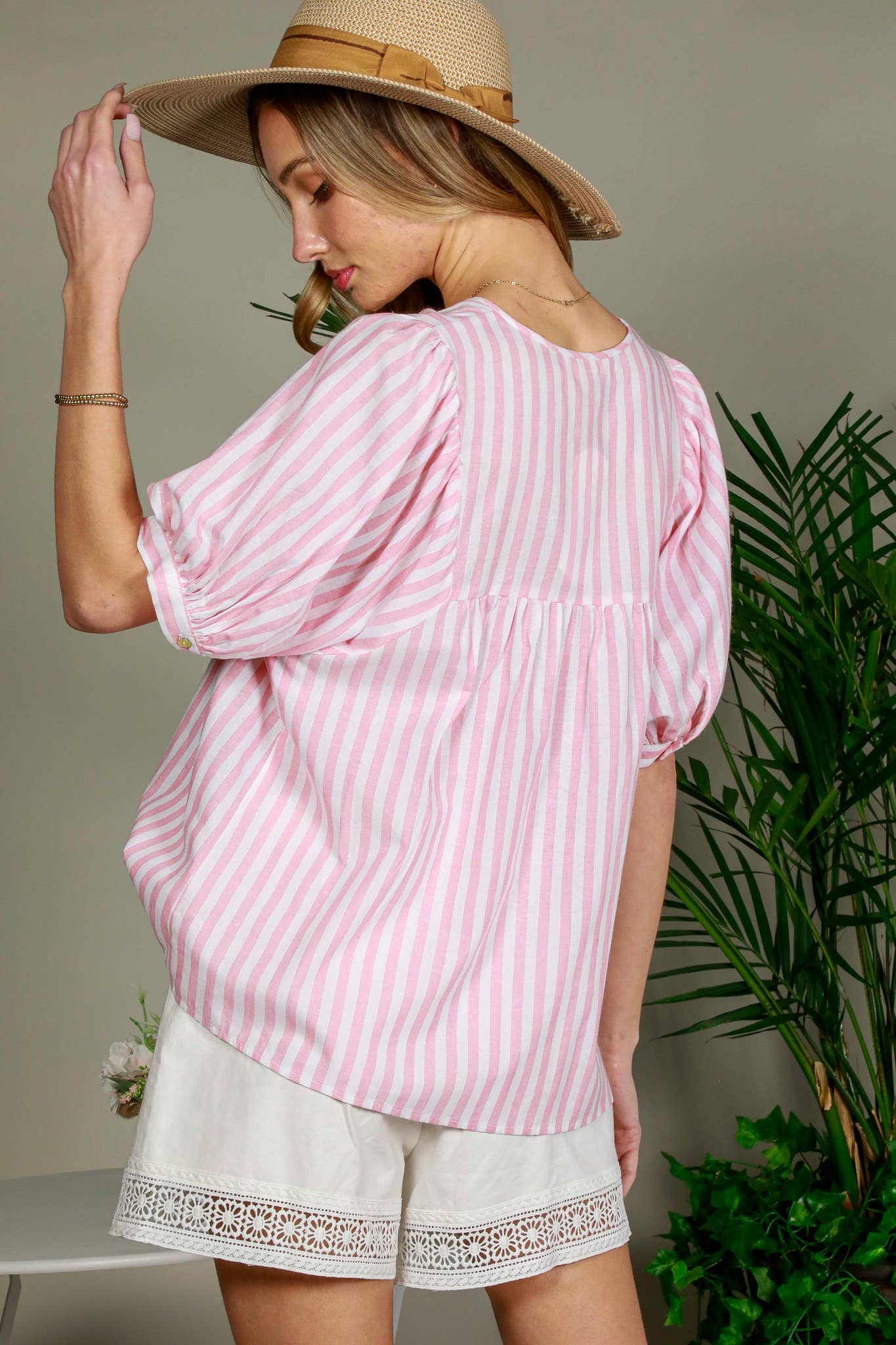 woman-wearing-Tie-Neck-Tassel-Trim-Short-Puff-Sleeve-Cotton-Top-in-pink-stripe-showing-the-back