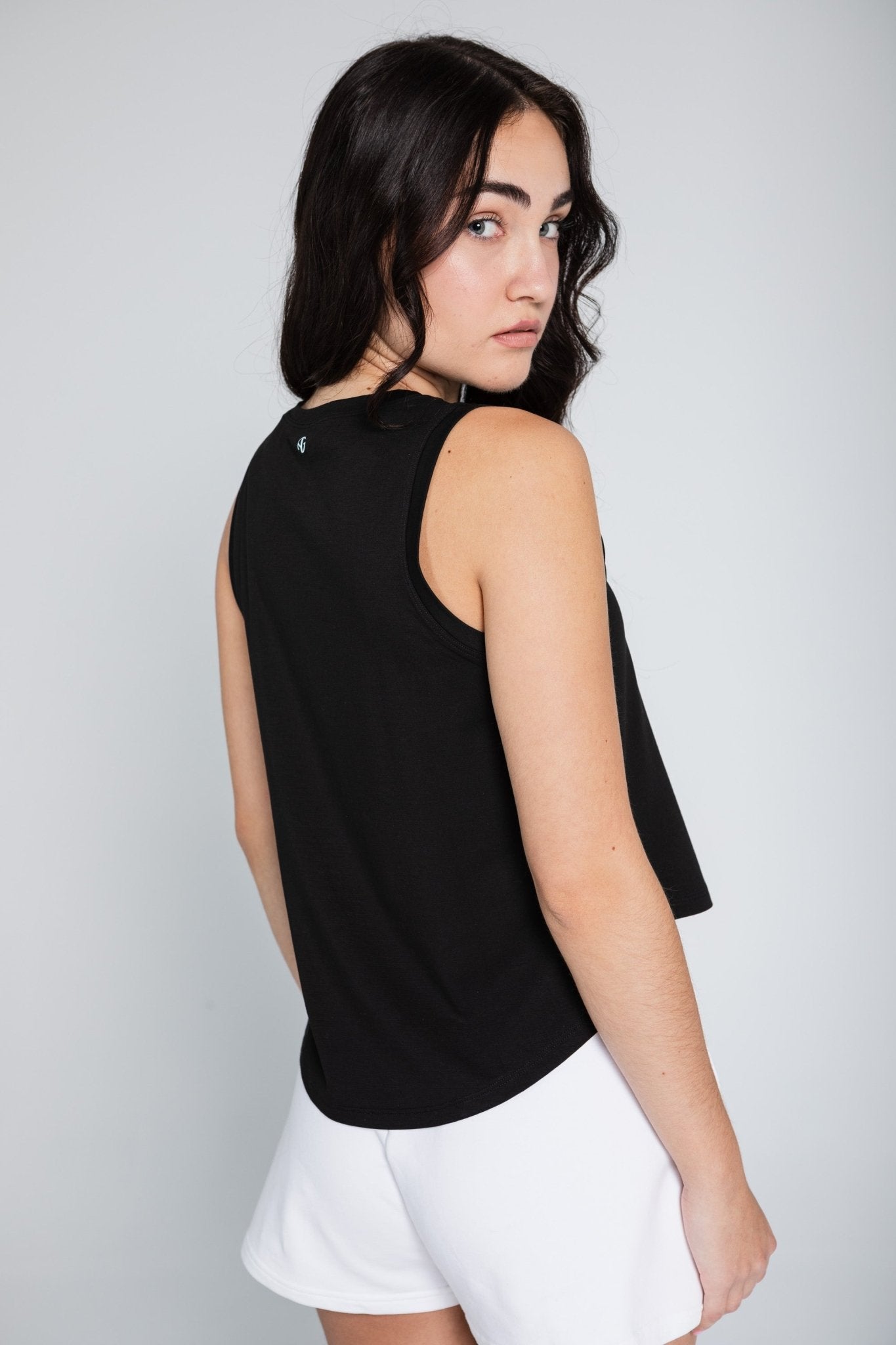 Back of black tank top showing high low hem and armhole.