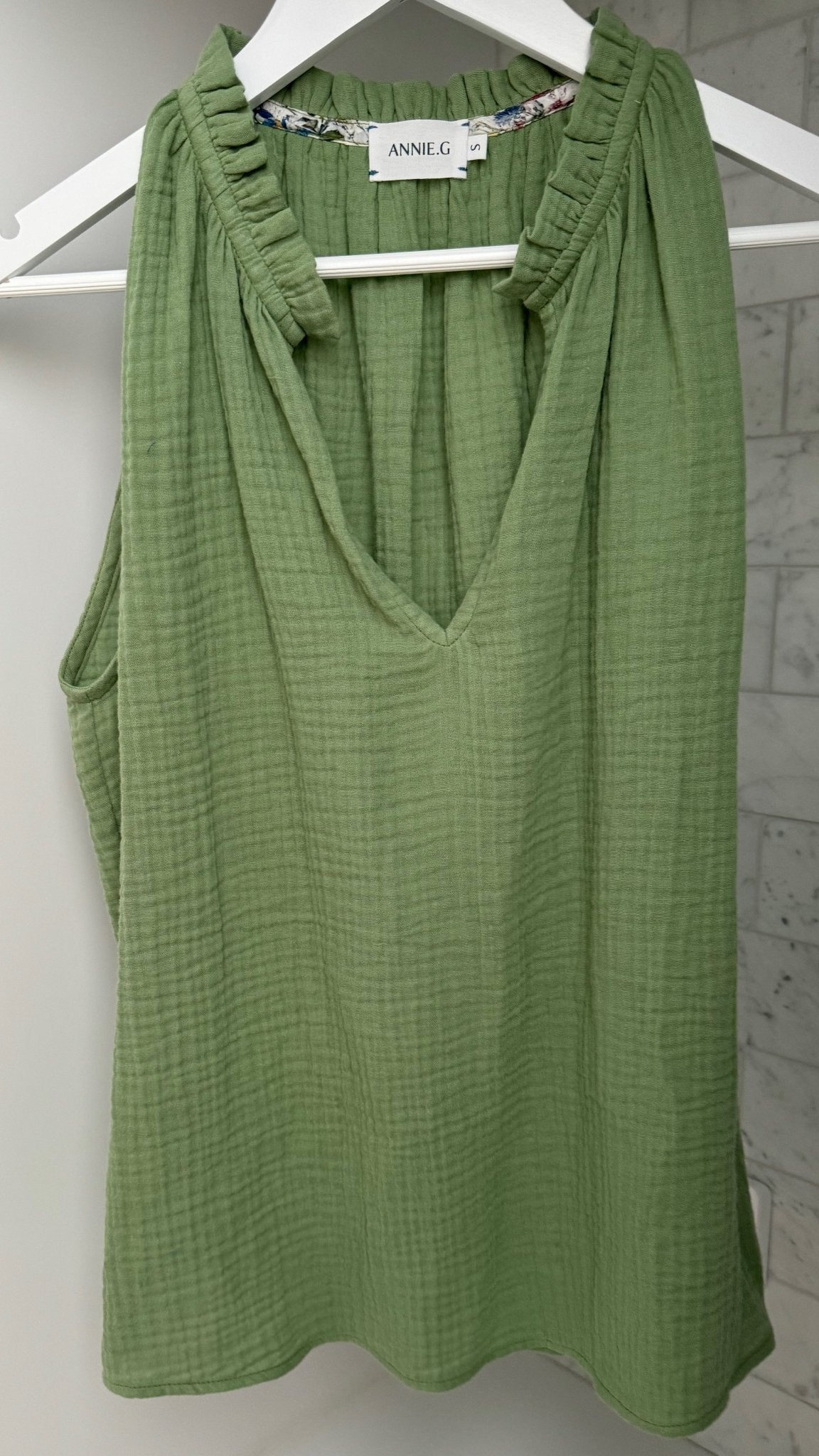 Green Cotton Gauze Tank with split neckline and frill hanging on a white hanger - ANNIE.G