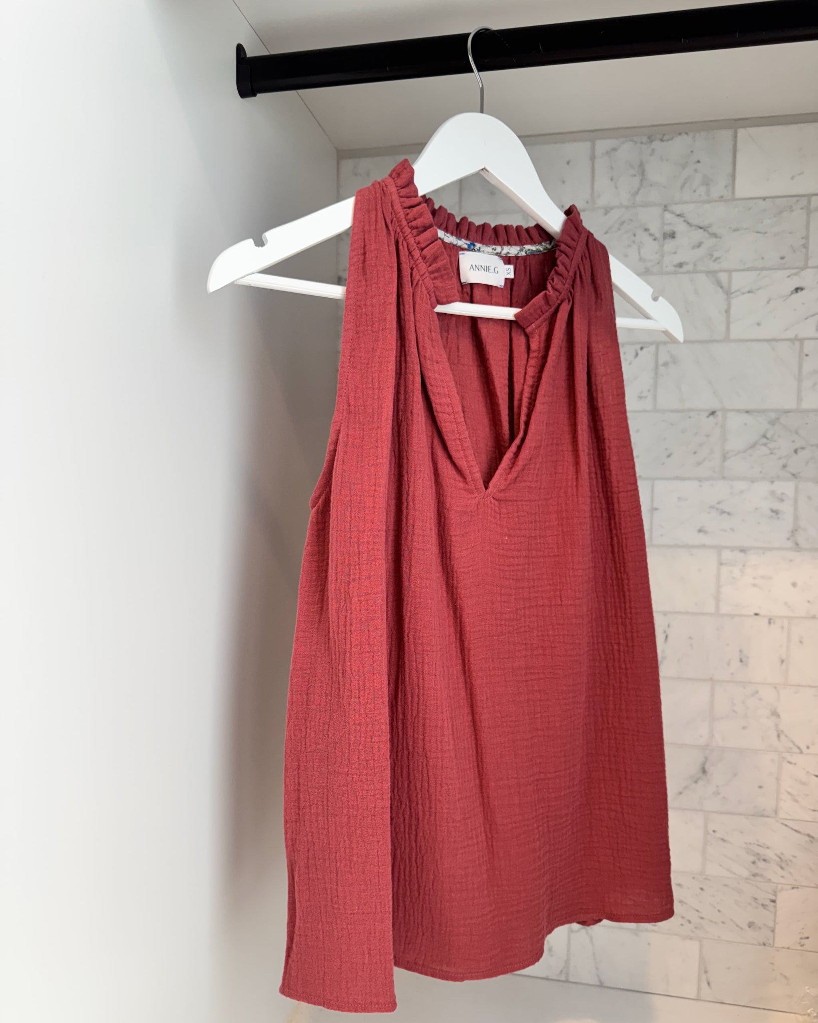 Maroon cotton gauze v-neckline top hanging on a white hanger