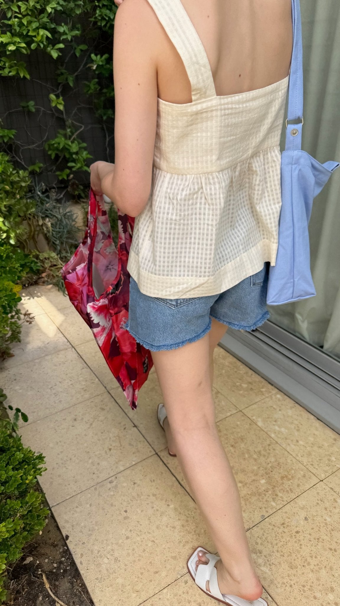 Woman walking in cream Wide Strap Cami Top and denim shorts.