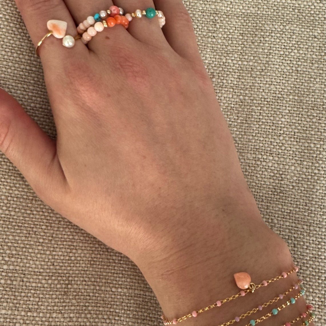 Bead Stretch rings and bracelets in coral and natural stones on a women's hand and wrist