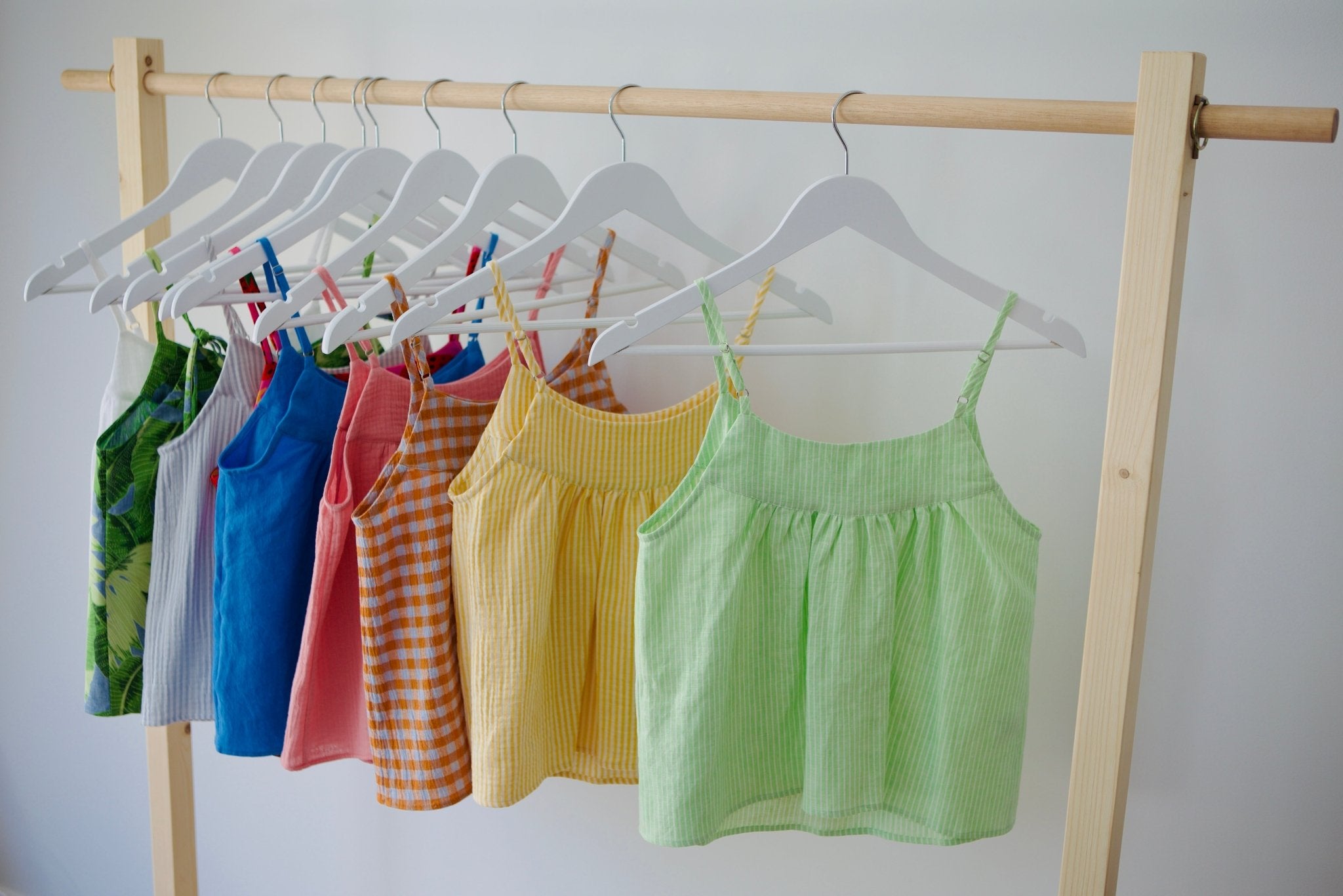 Hanging cami tops in various colours on a rack.
